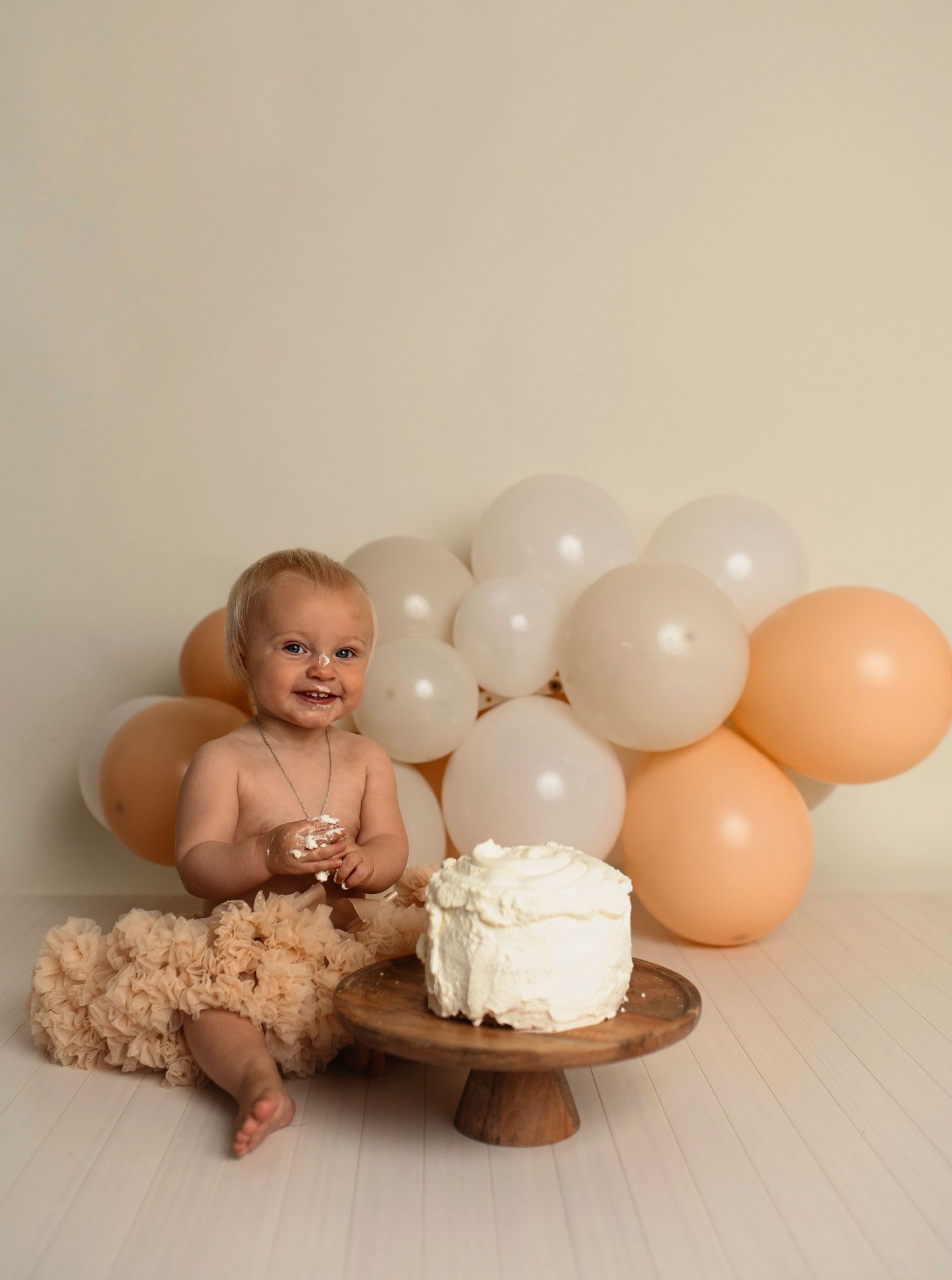 Flicka på sin smash the cake fotografering hos Lovestories By Sara. Flickan har på sig en beige tyllkjol.