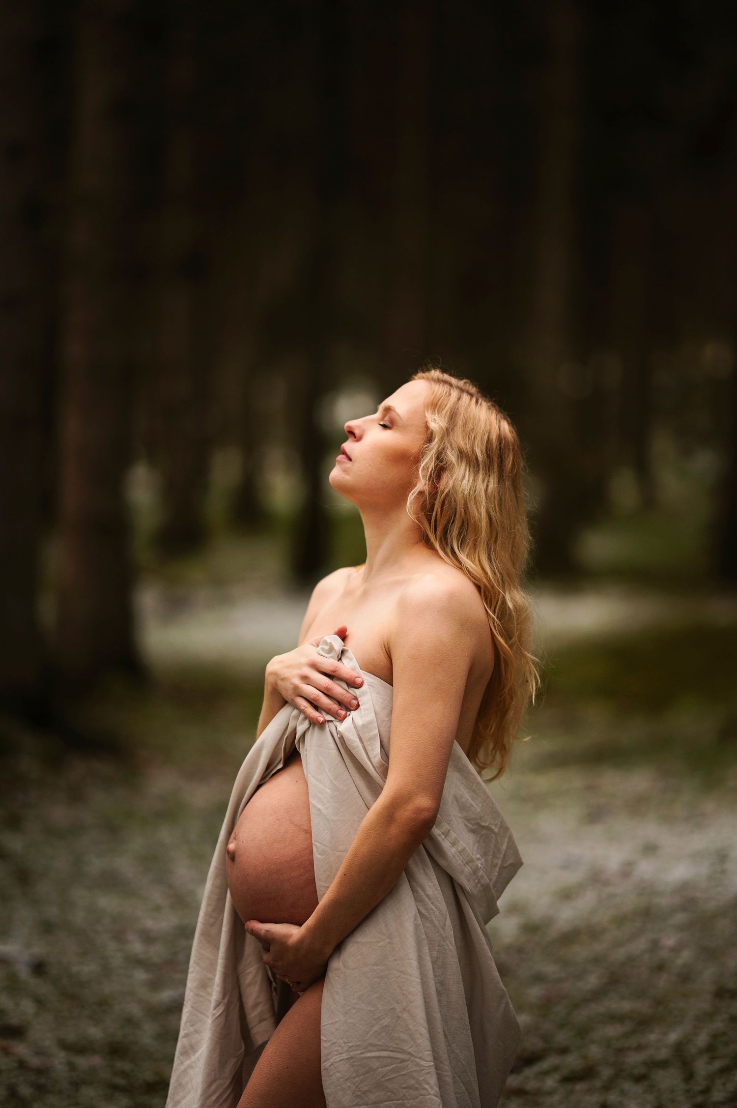 Vacker gravid kvinna på gravidfotografering hos Lovestories By Sara. Nakenfoto i skogen.