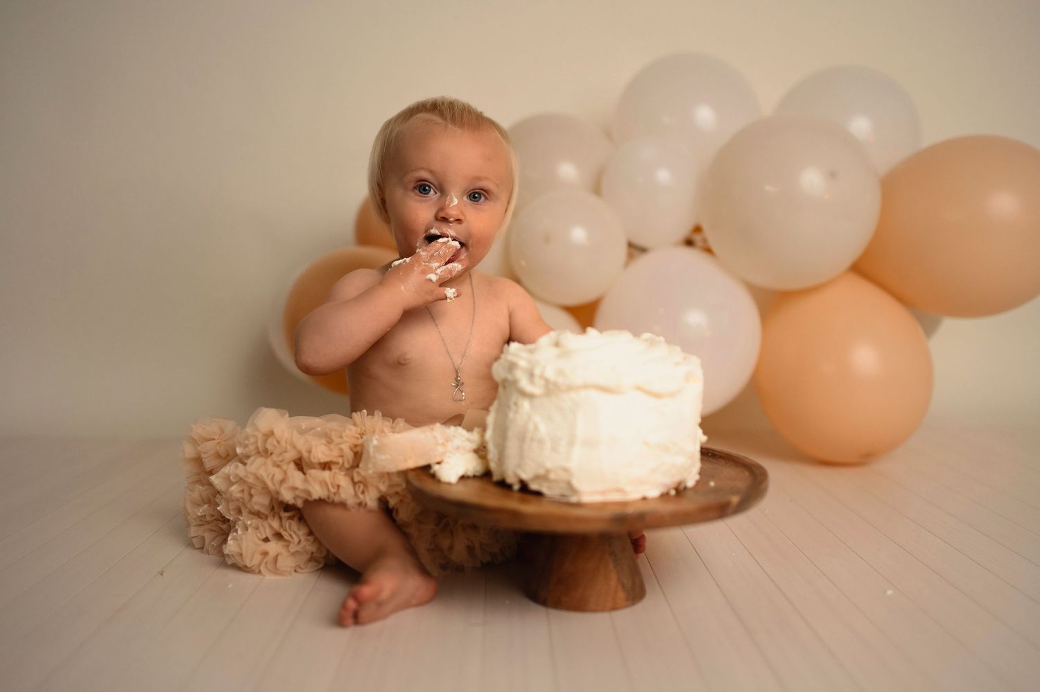 Flicka på sin smash the cake fotografering hos Lovestories By Sara. Flickan har på sig en beige tyllkjol.