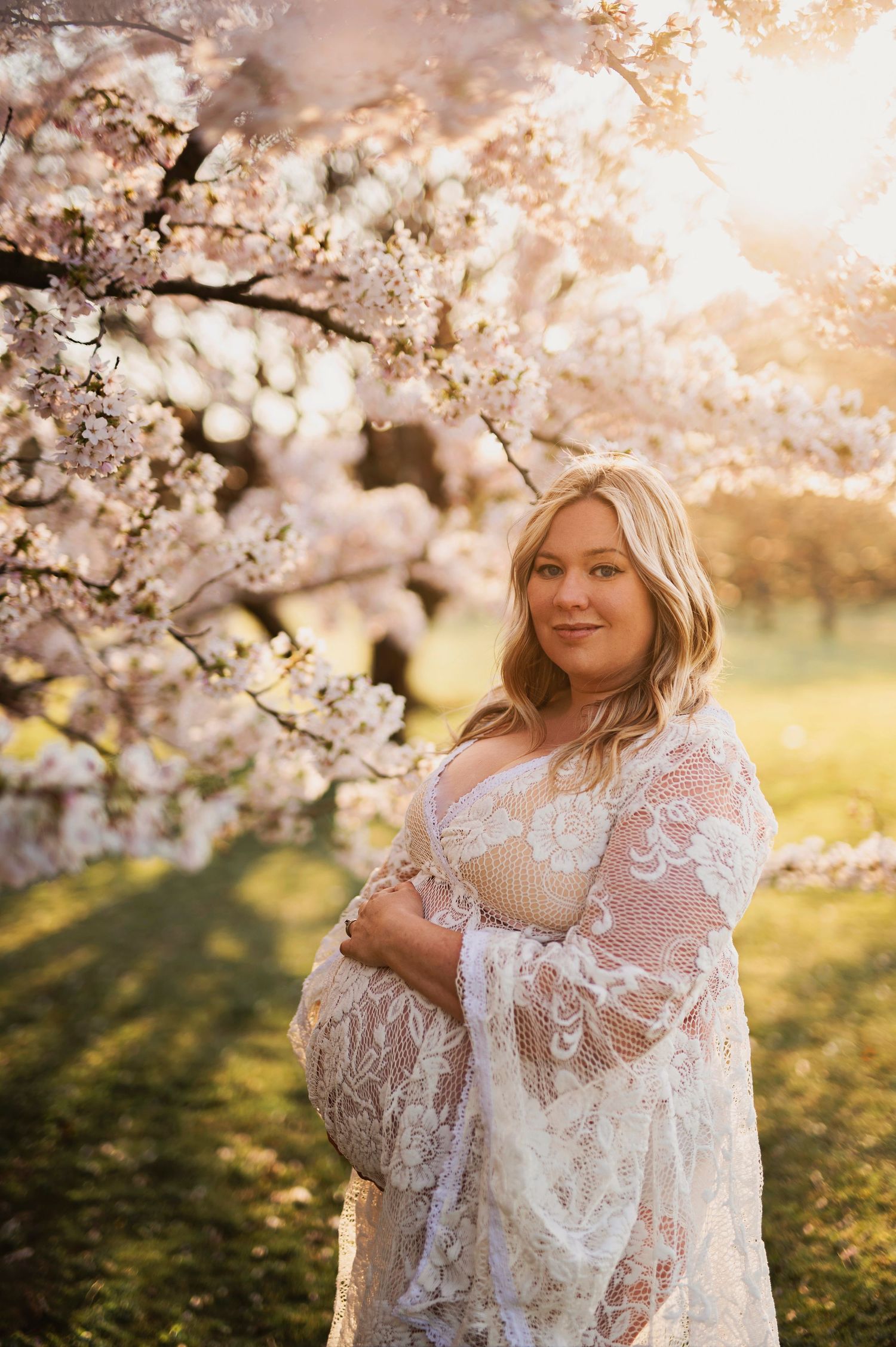 Vacker Gravidfotografering bland körsbärsträd fotograferade av Lovestories By Sara