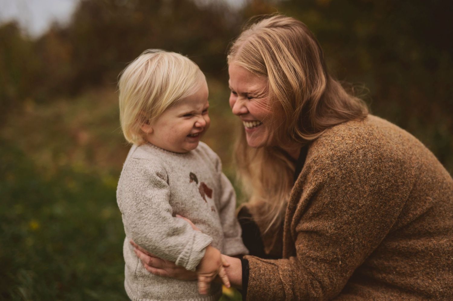 Genuine laughter shared during outdoor autumn photo session.