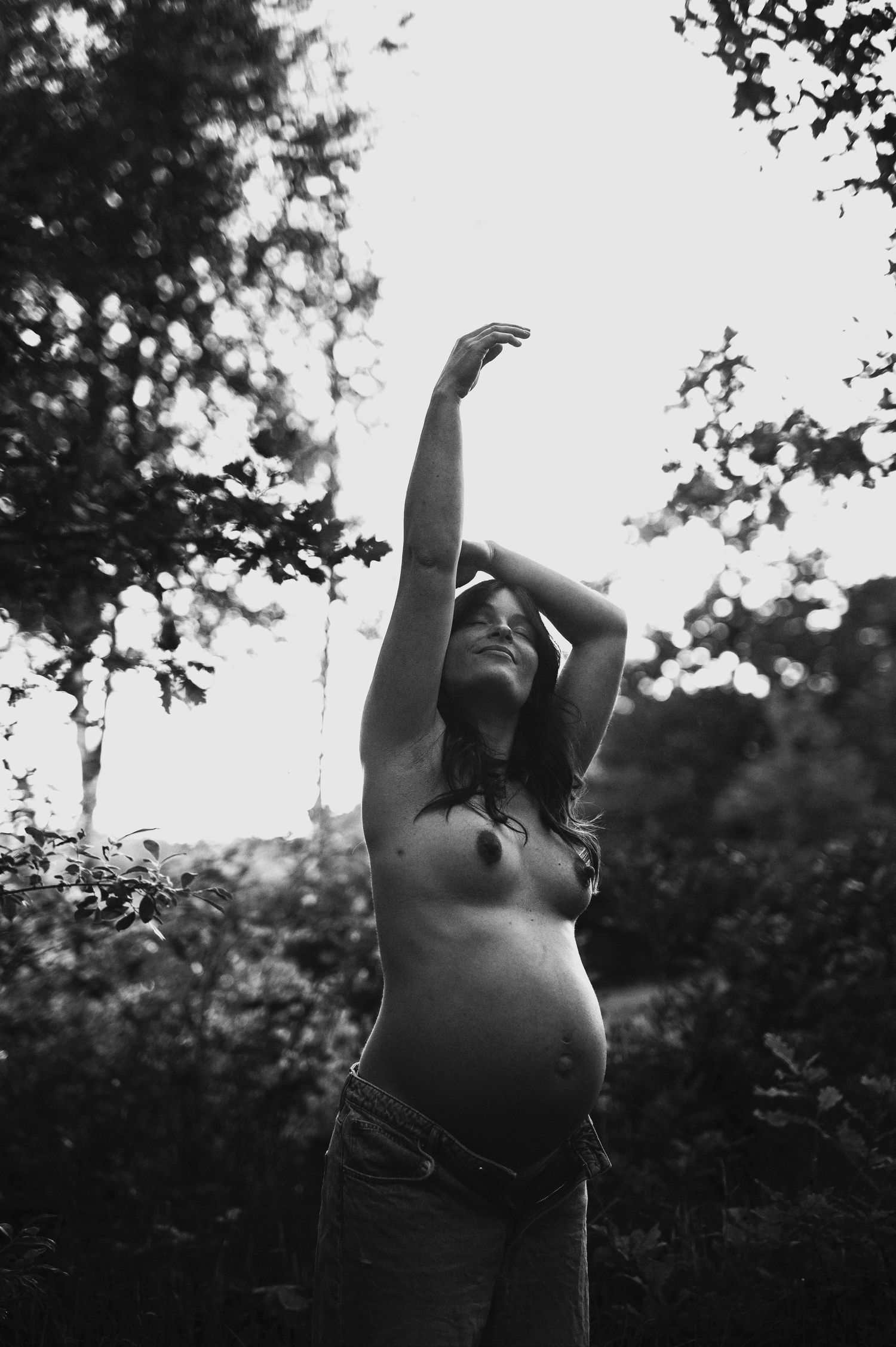 Artistic black and white silhouette of an expectant mother in nature.