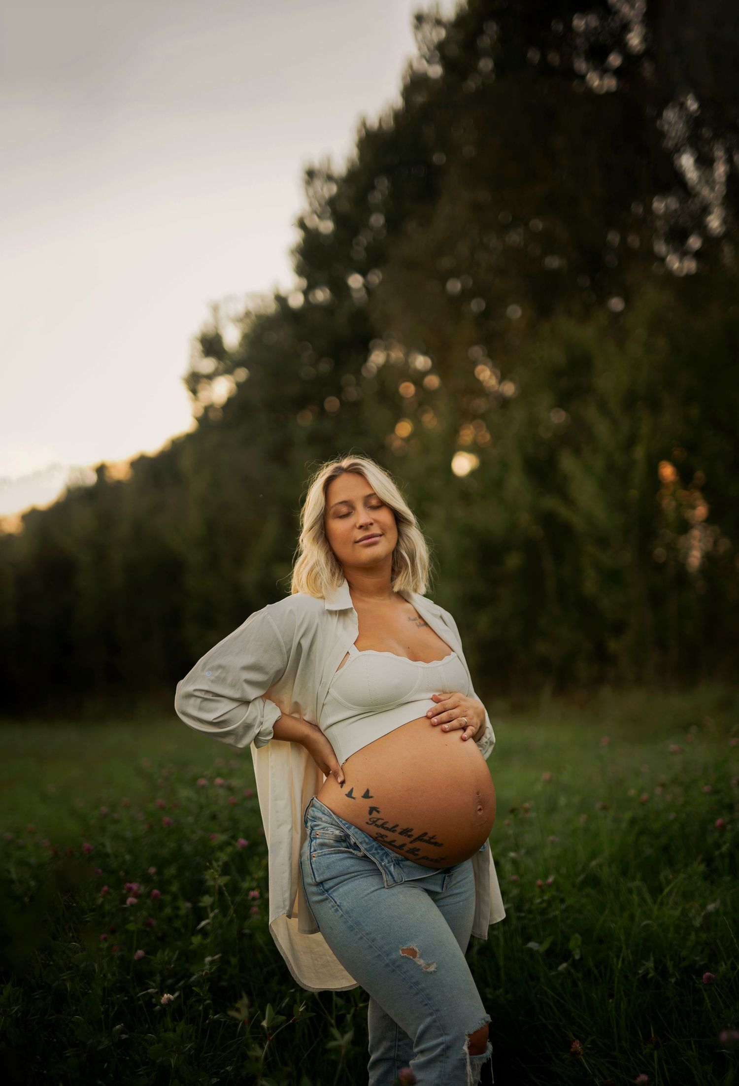 Sunset maternity session in a wildflower field with warm evening light.