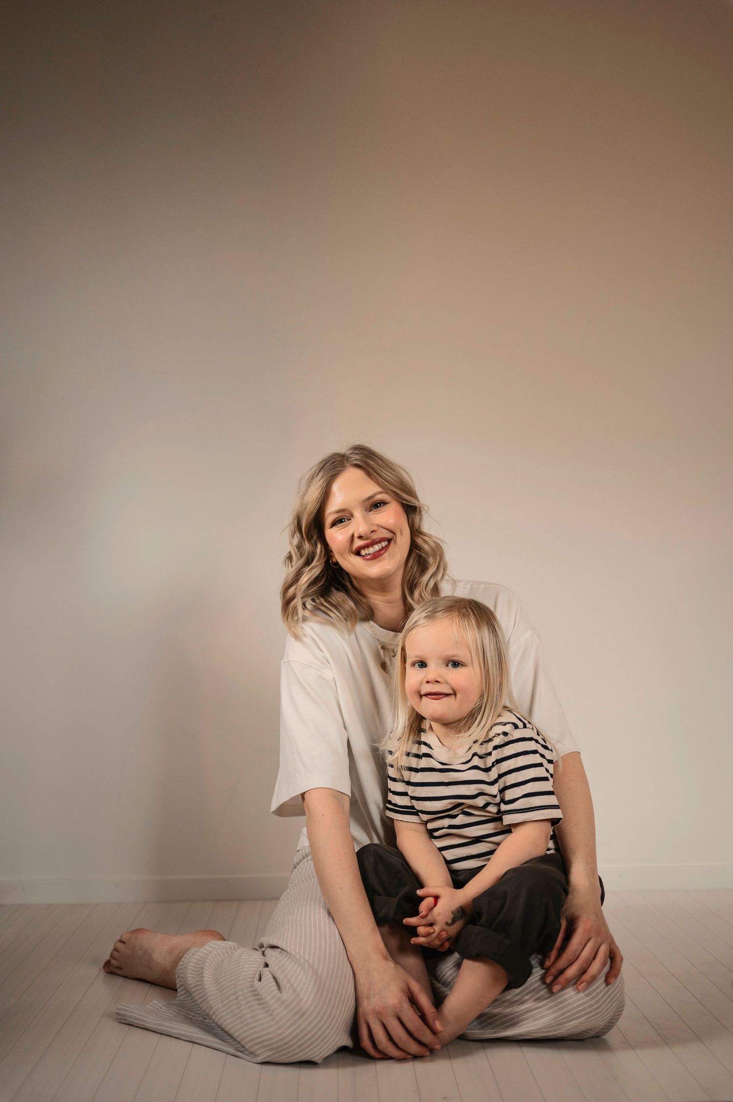 A heartwarming series of candid poses showing playful moments between a parent and child on a neutral backdrop.