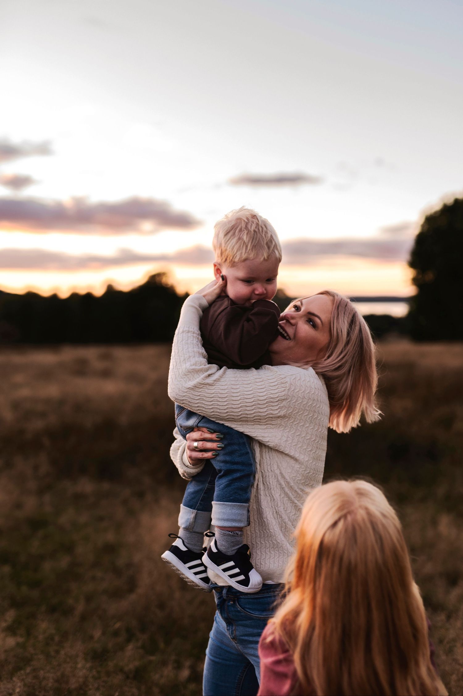Tender moment captured during golden hour in a rustic field setting.