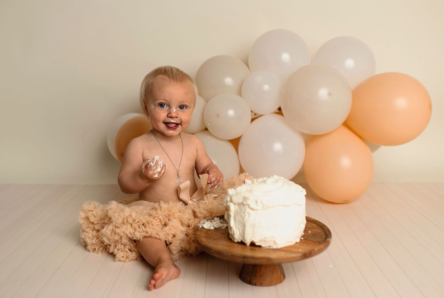 Flicka på sin smash the cake fotografering hos Lovestories By Sara. Flickan har på sig en beige tyllkjol.