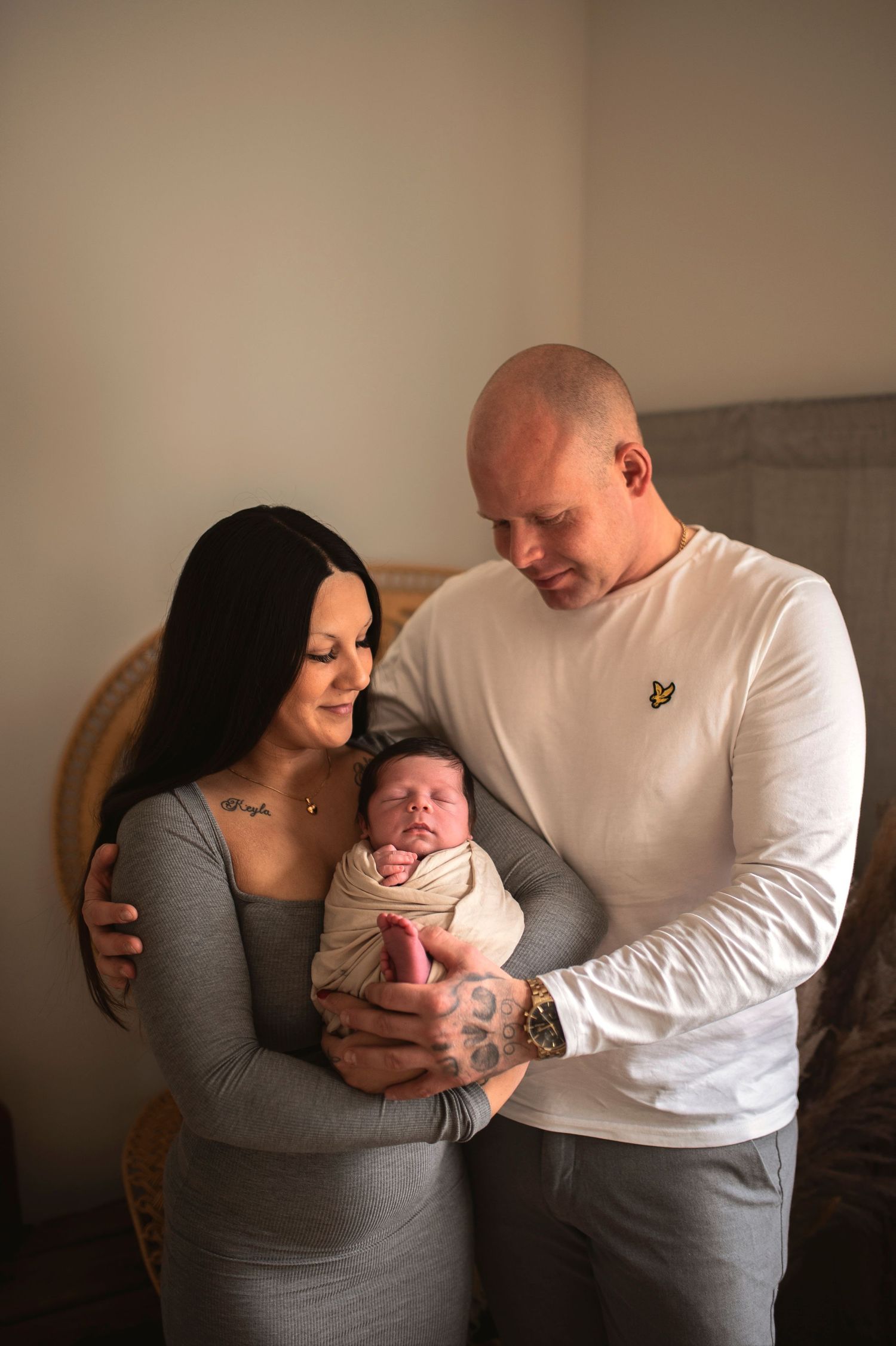 Family shares intimate moment with newborn baby in home setting.