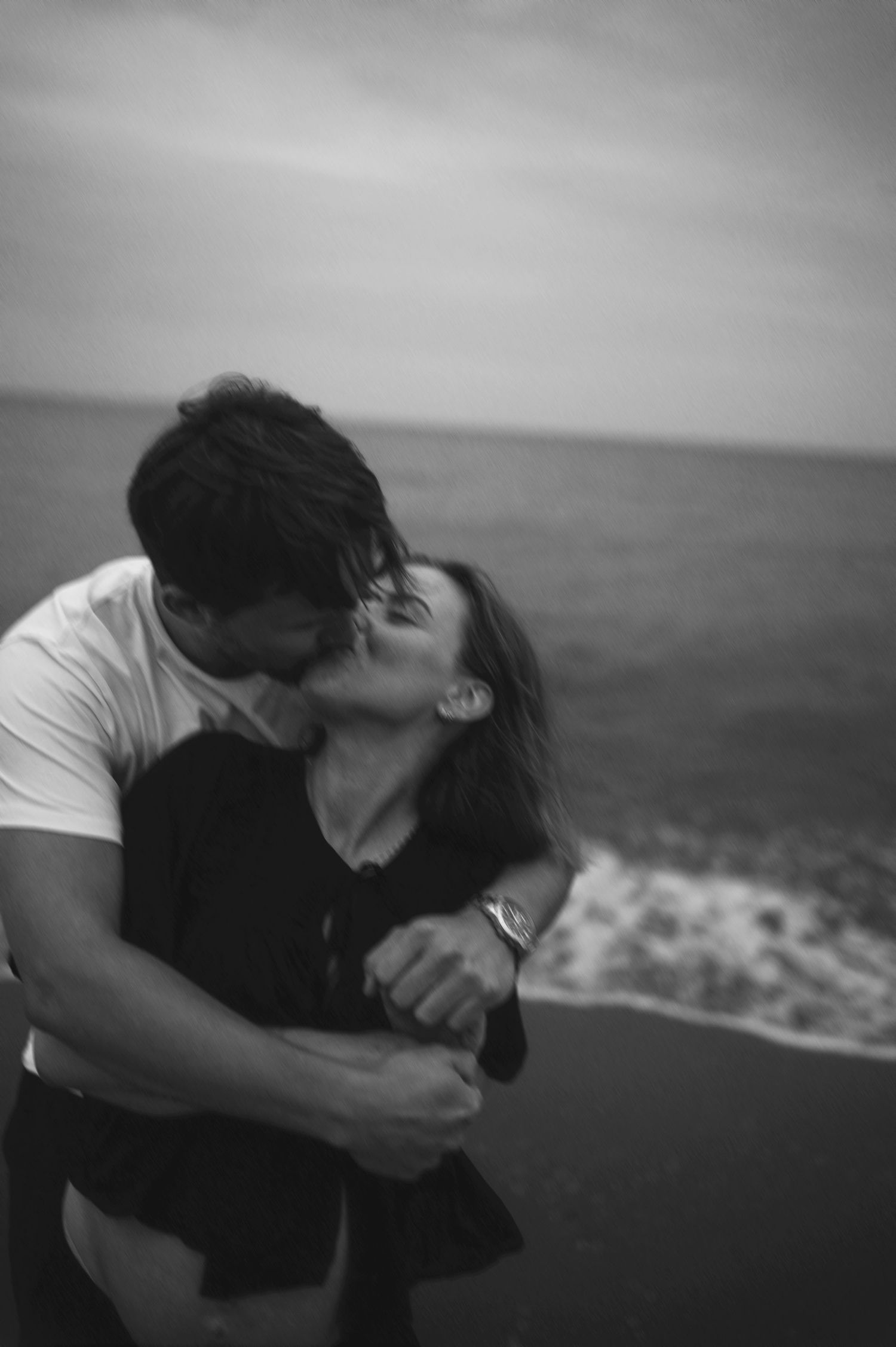 Romantic seaside moment captured in black and white photography.