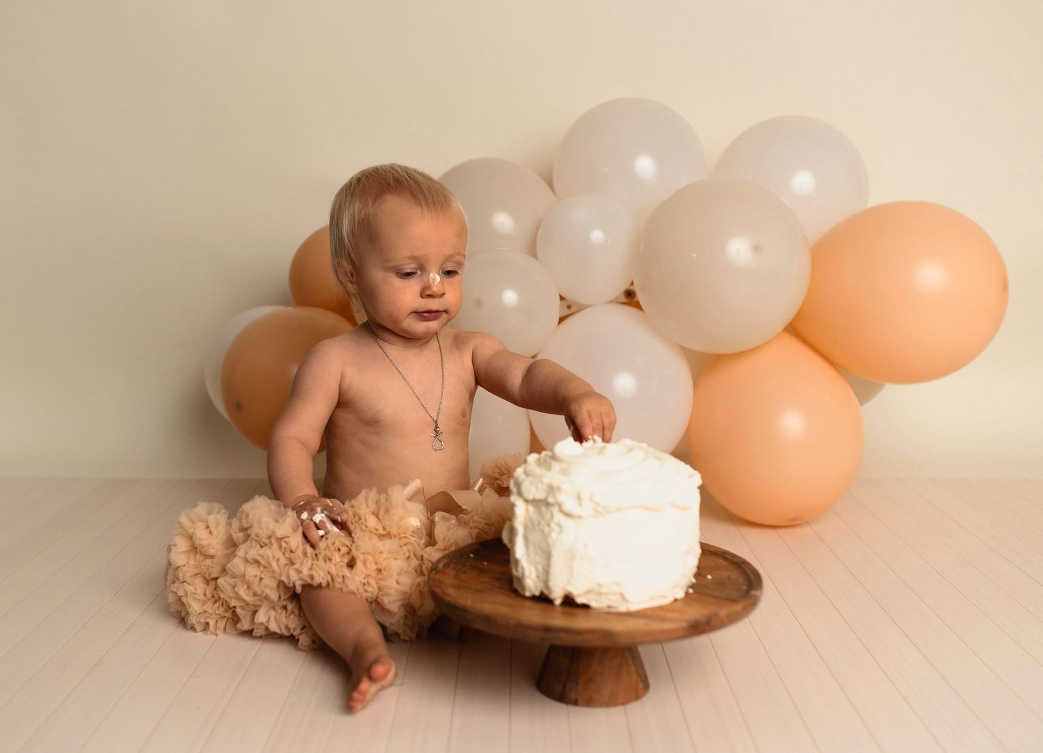 Flicka på sin smash the cake fotografering hos Lovestories By Sara. Flickan har på sig en beige tyllkjol.
