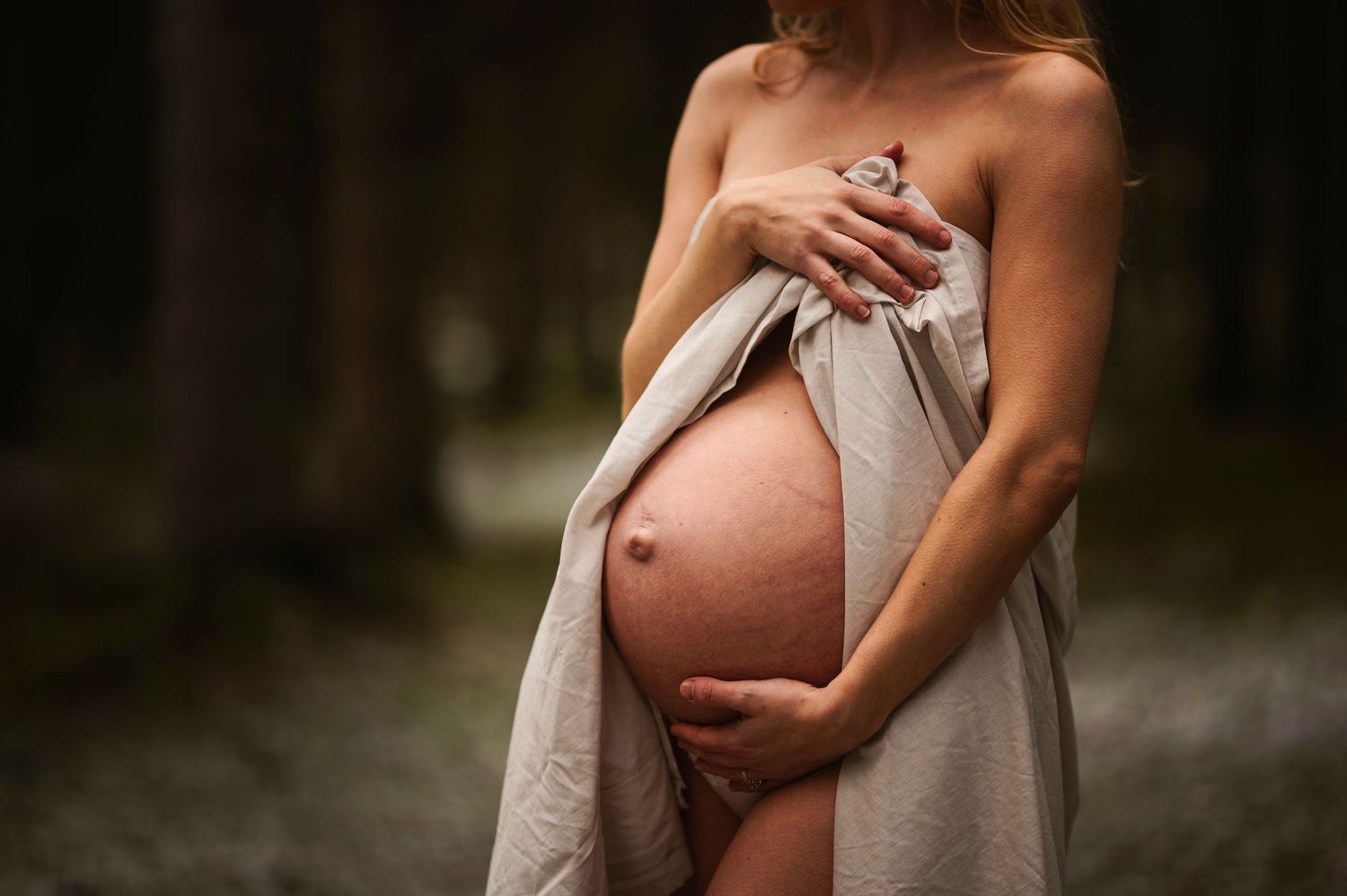 Vacker gravid kvinna på gravidfotografering hos Lovestories By Sara. Nakenfoto i skogen.