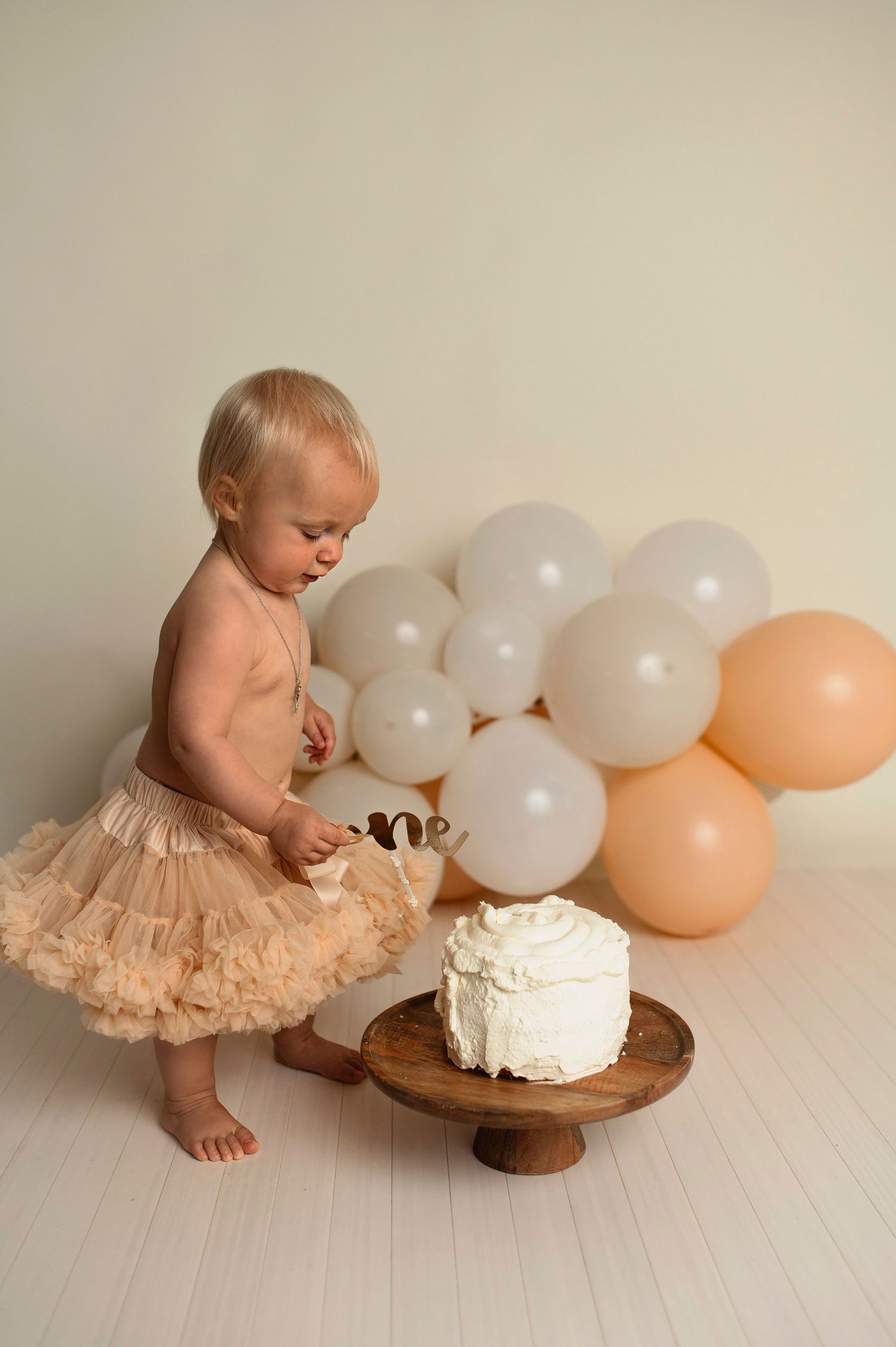Flicka på sin smash the cake fotografering hos Lovestories By Sara. Flickan har på sig en beige tyllkjol.