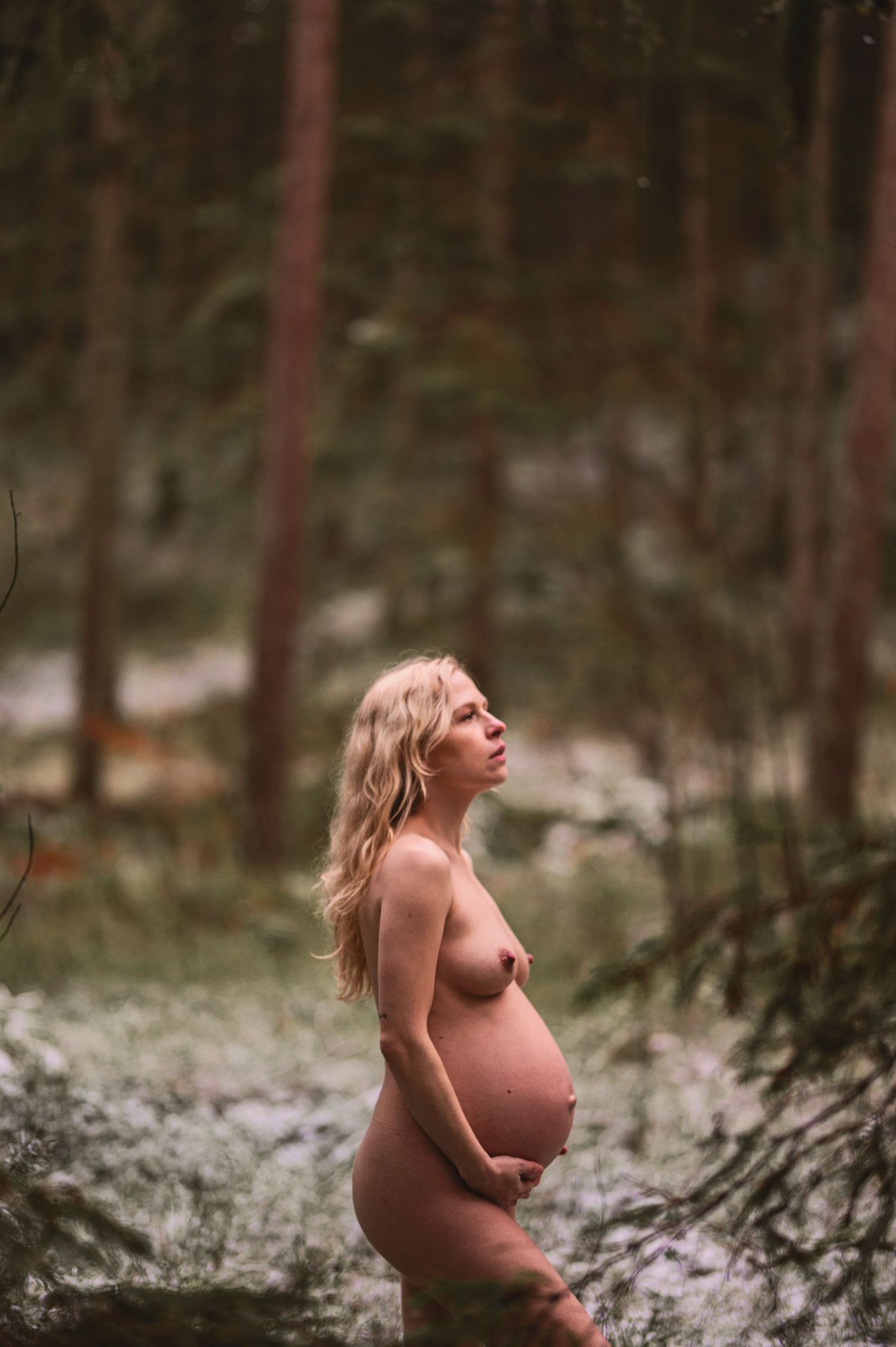 Vacker gravid kvinna på gravidfotografering hos Lovestories By Sara. Nakenfoto i skogen.