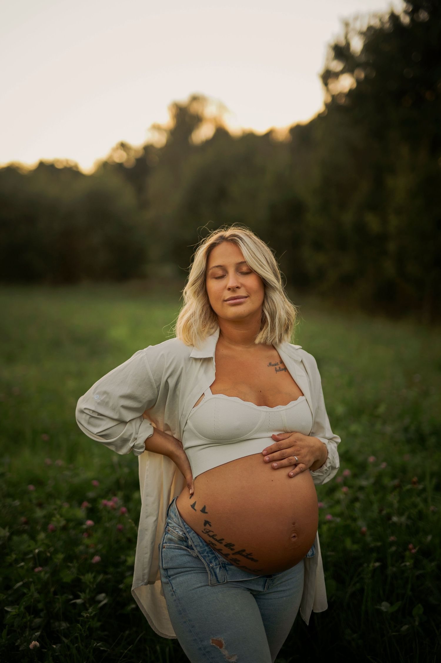 Outdoor pregnancy photo featuring a white crop top and cream button-down shirt.