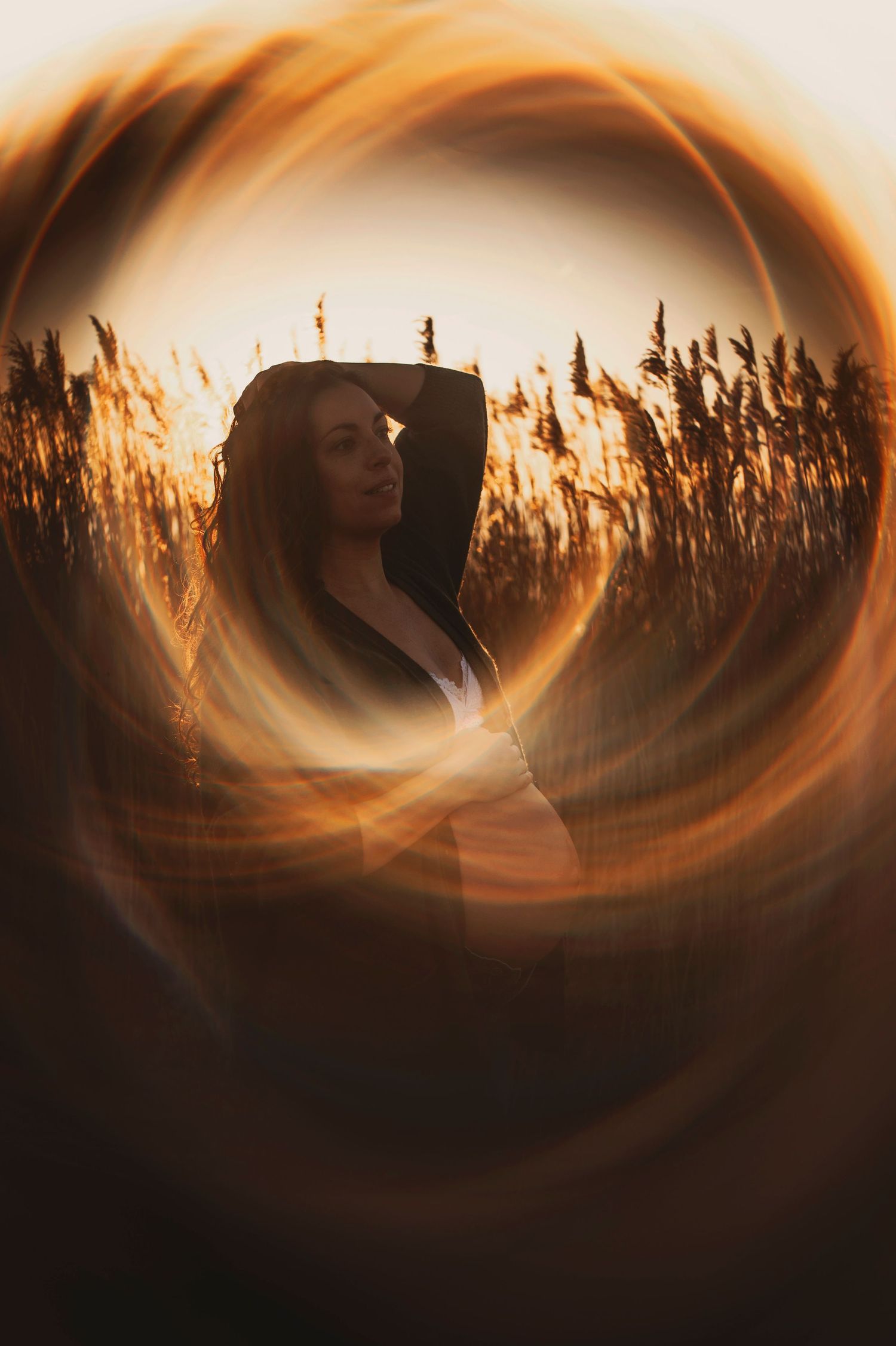 Portrait with circular light effect showing a silhouette against golden wheat stalks.