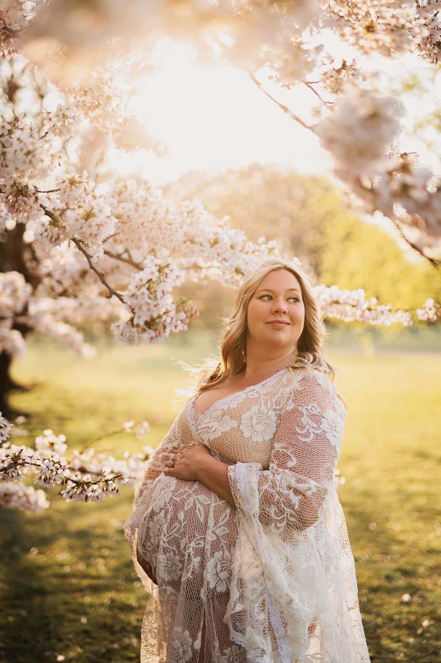 Gravidfotografering bland körsbärsträd fotograferade av Lovestories By Sara