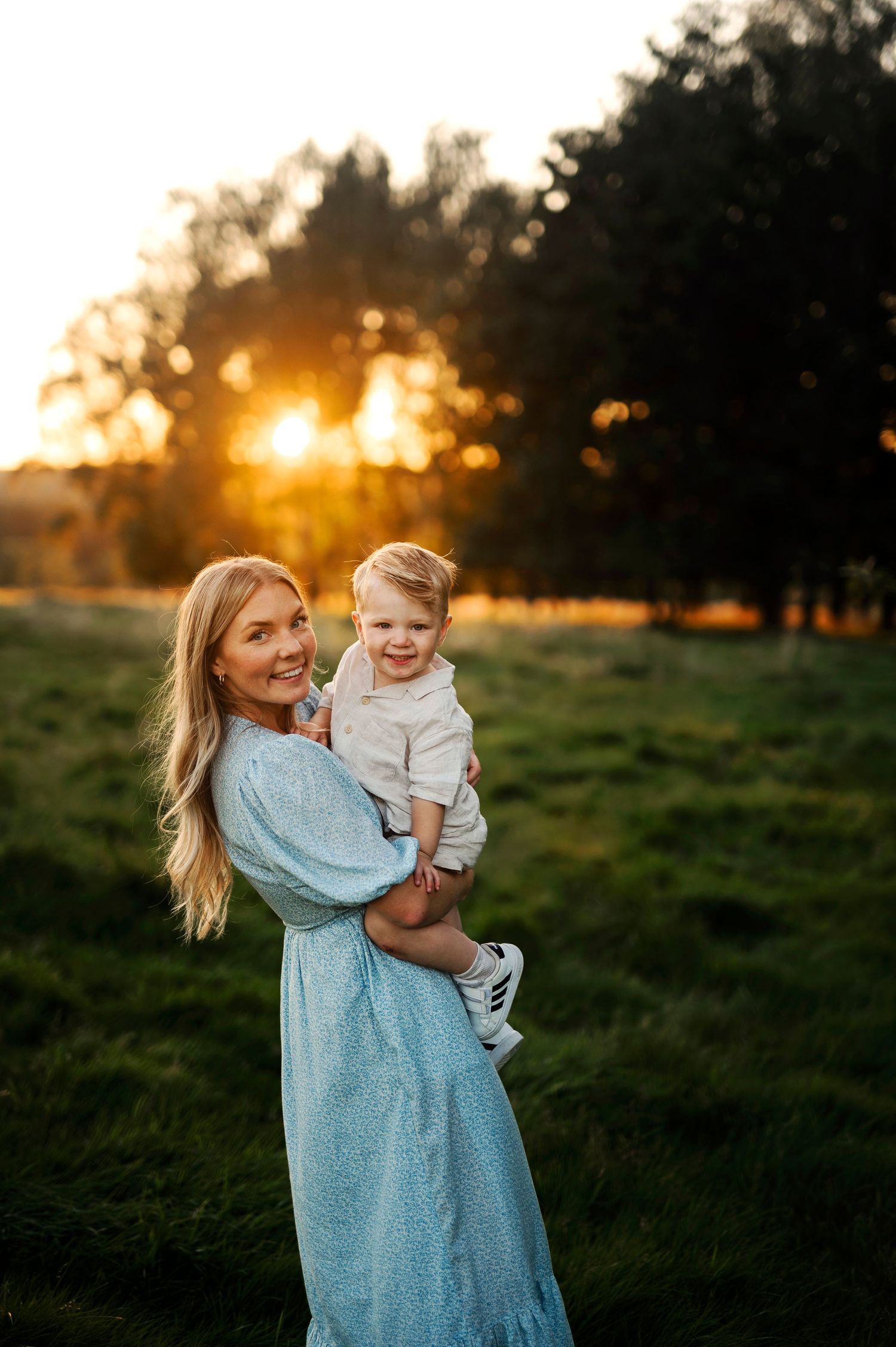 Beautiful outdoor portrait with golden sunset light streaming through trees in background.