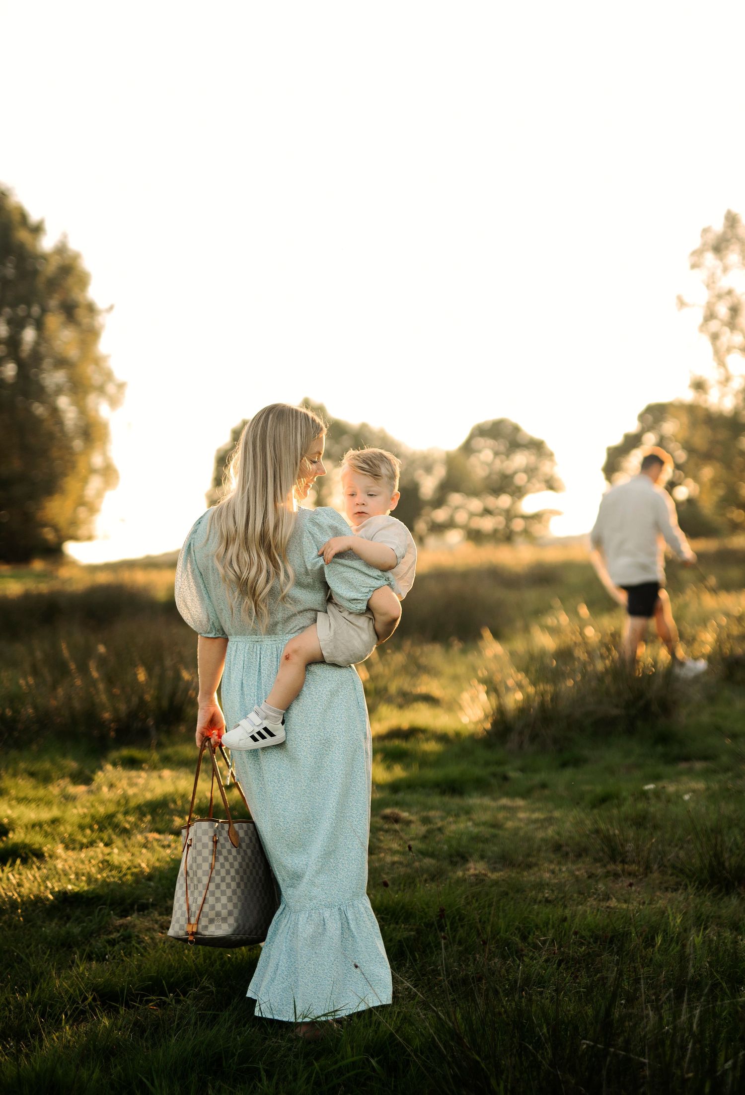 A tender interaction between two figures in a sunlit field during golden hour.