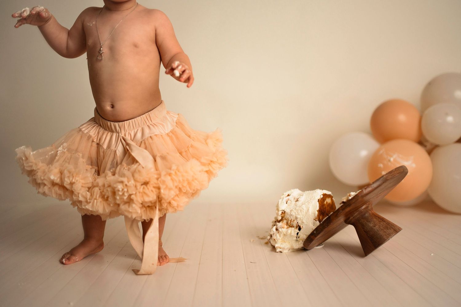 Flicka på sin smash the cake fotografering hos Lovestories By Sara. Flickan har på sig en beige tyllkjol.