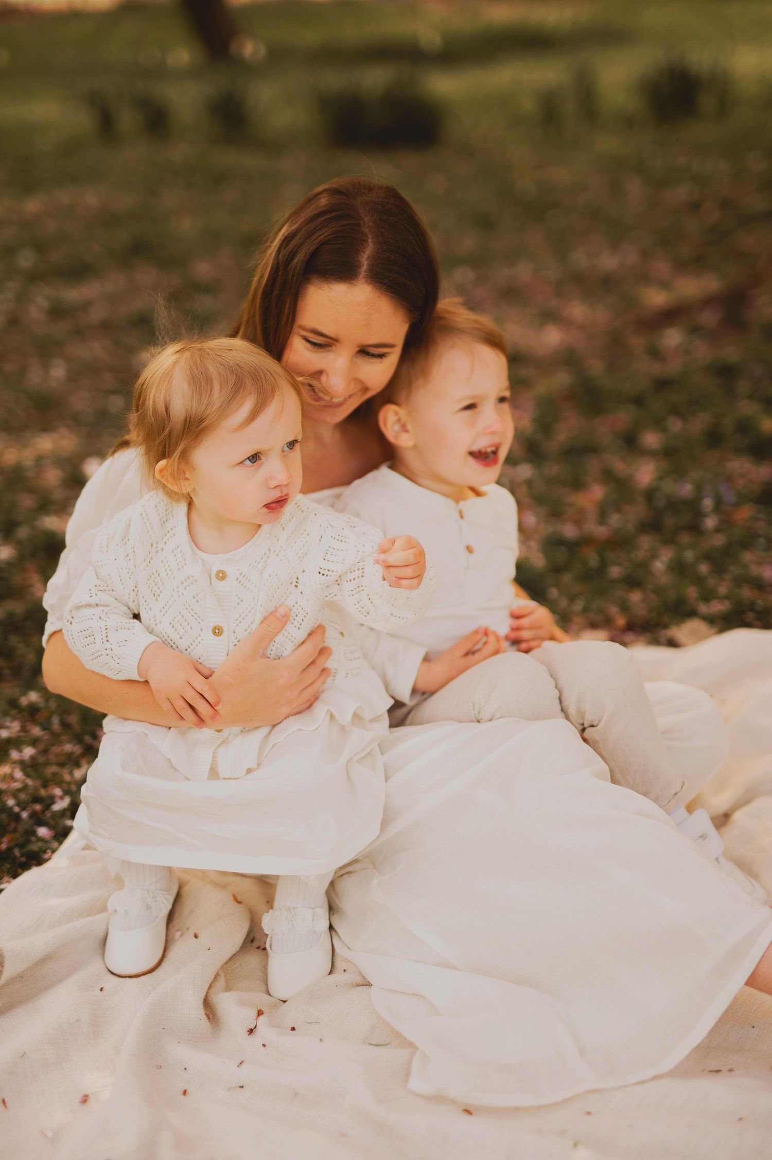 A joyful outdoor family portrait with everyone dressed in white.
