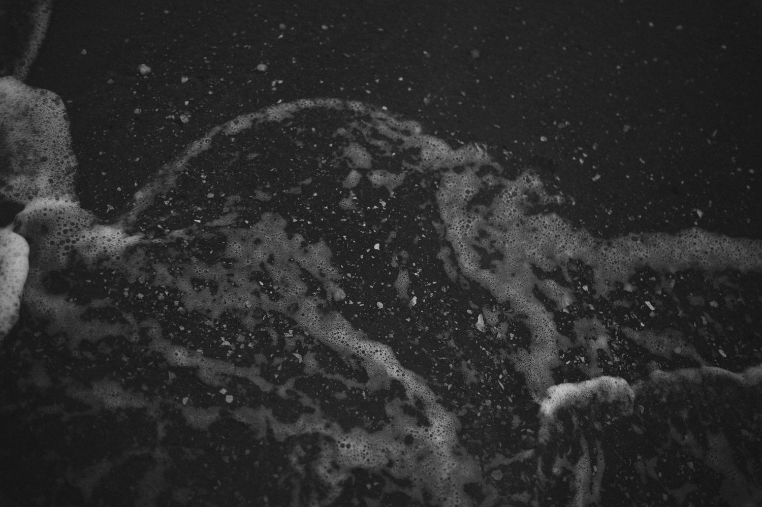 Abstract black and white photograph of water splashing and creating dynamic patterns.