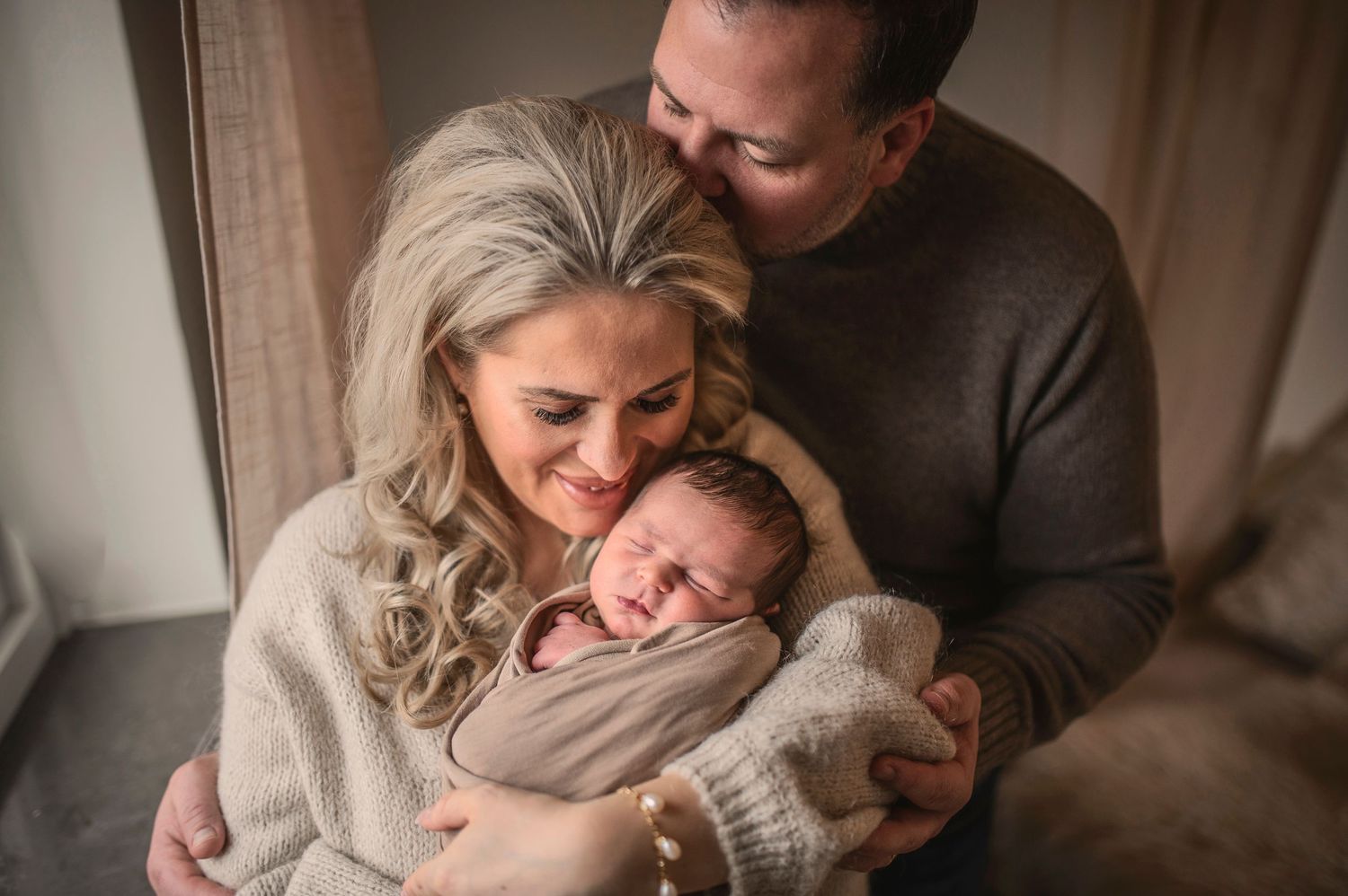 Parent and child share tender moments together in a cozy room with warm lighting and neutral tones.
