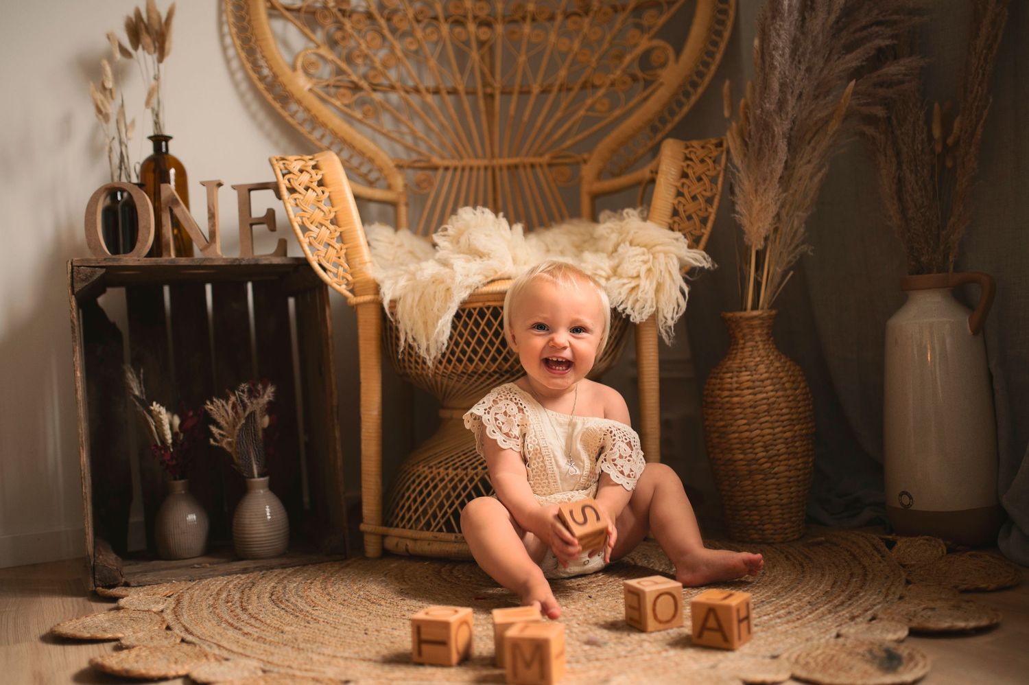 Rustic birthday portrait featuring wicker chair, wooden toys, and neutral toned decorations.