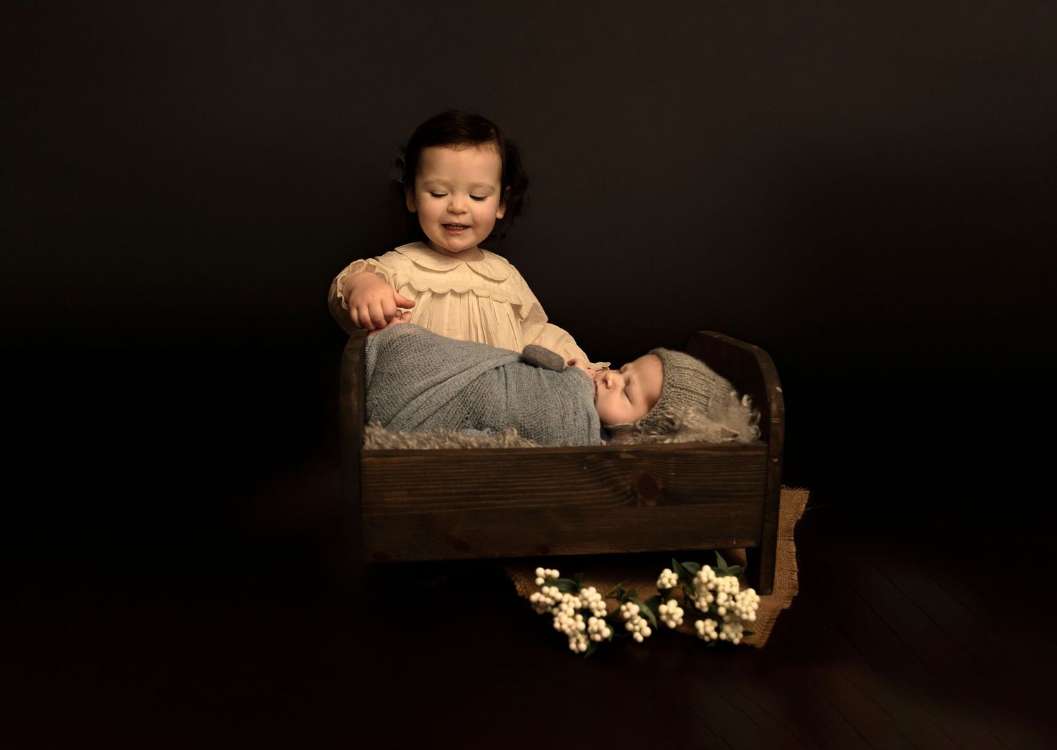 Studio portrait with wooden box and white flowers.