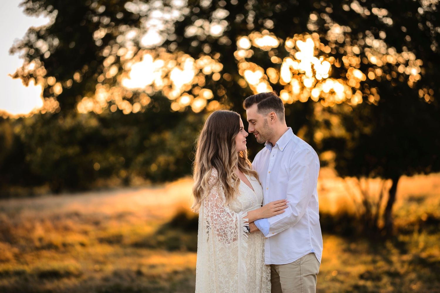 A romantic couple in white and khaki share an intimate moment at golden hour.