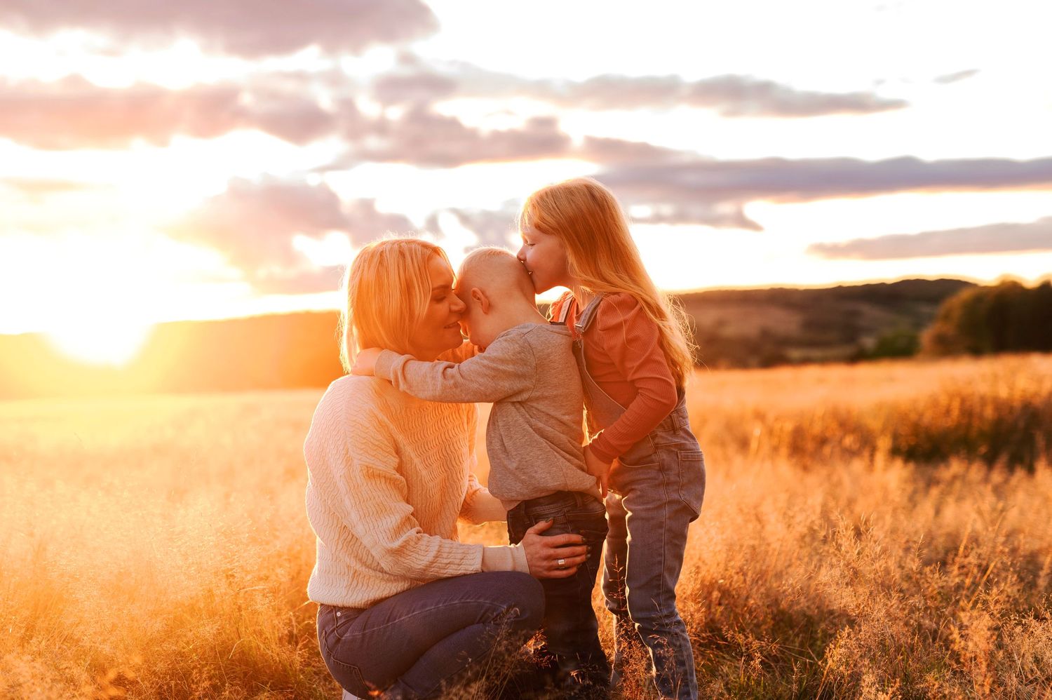 Heartwarming family moment captured during sunset in a rustic field setting.
