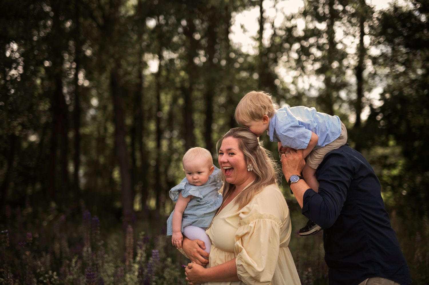 Family shares joyful moment together in coordinated outfits during outdoor photo session.