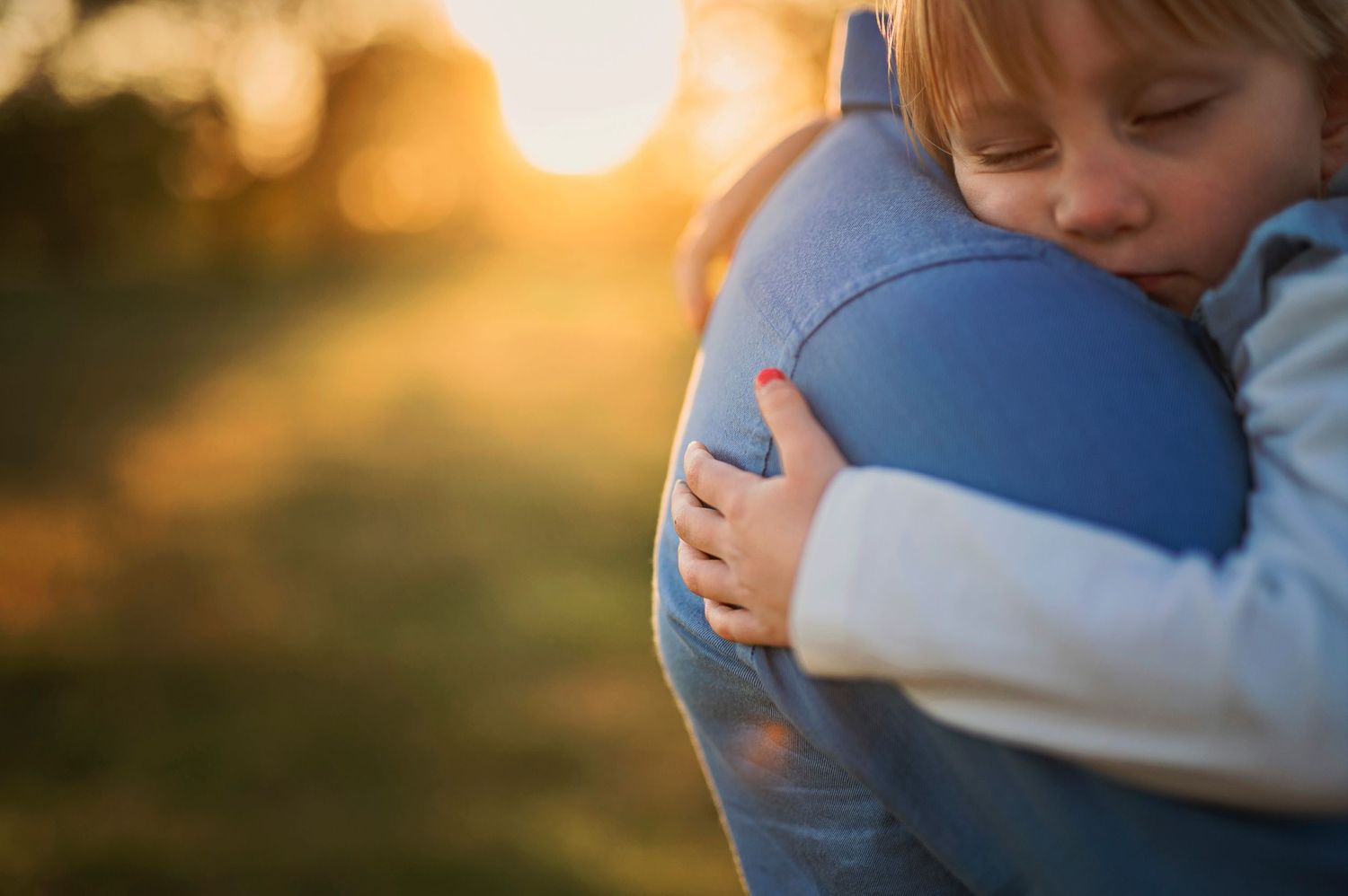 Close-up of tender embrace against sunset backdrop in outdoor setting.
