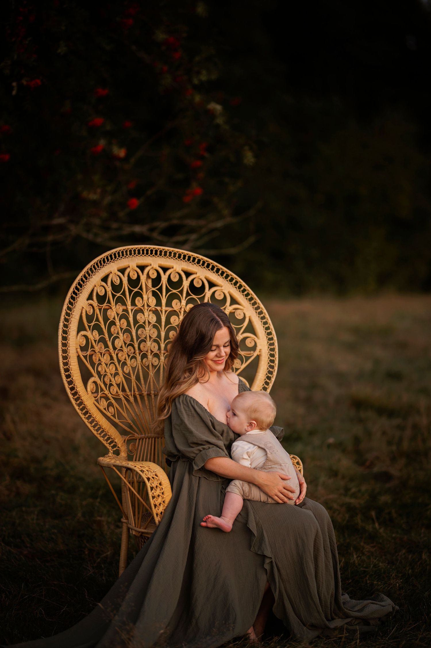 A tender moment shared in an ornate peacock chair under flowering trees.
