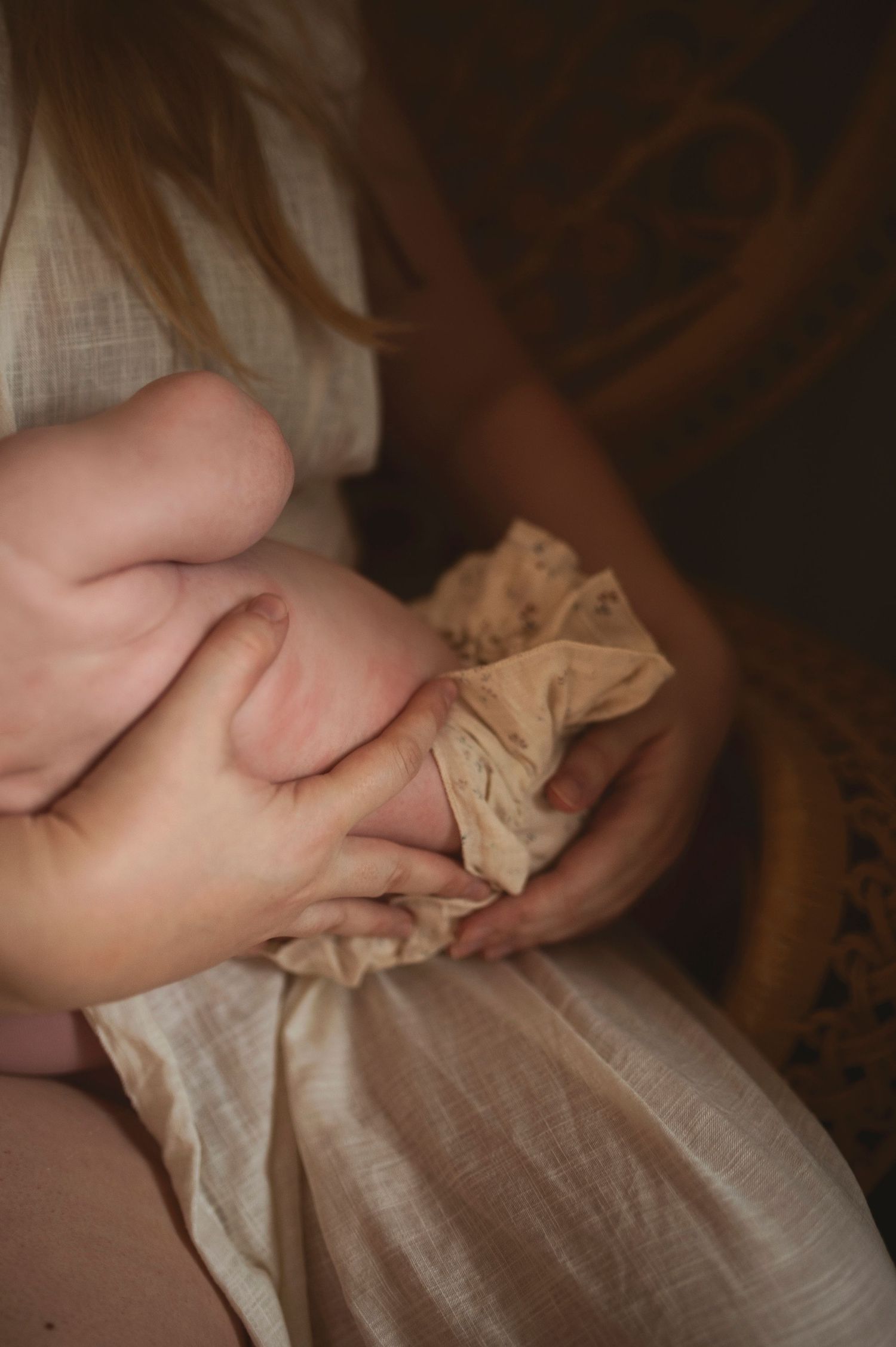 Close-up detail of hands holding fabric in soft natural light.