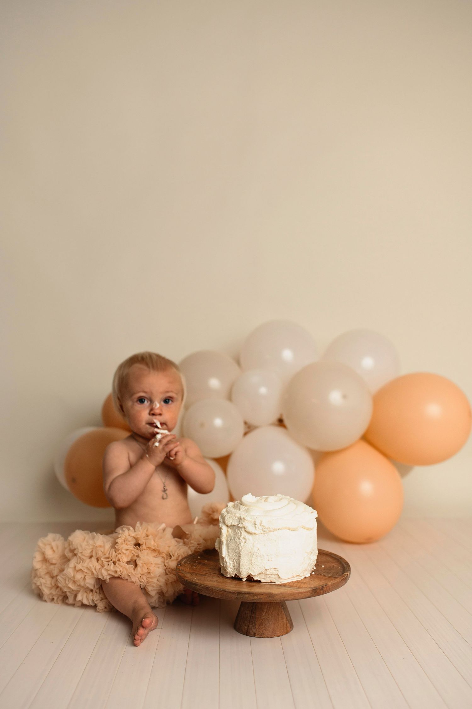 Flicka på sin smash the cake fotografering hos Lovestories By Sara. Flickan har på sig en beige tyllkjol.