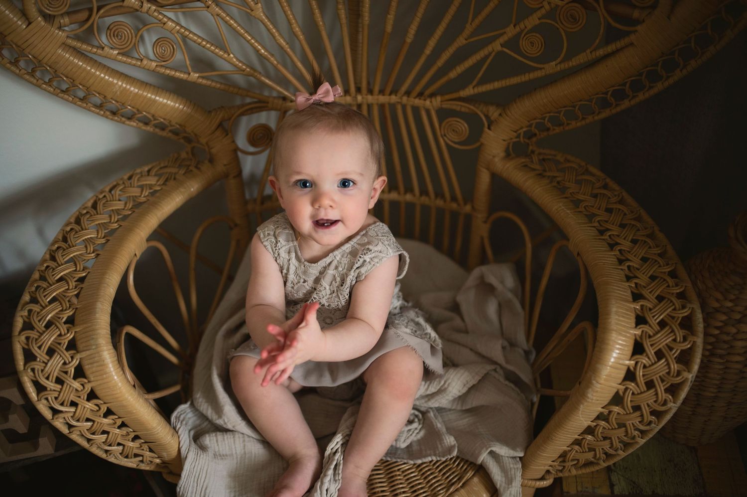 An intimate portrait in a wicker chair showing soft lighting and natural textures.