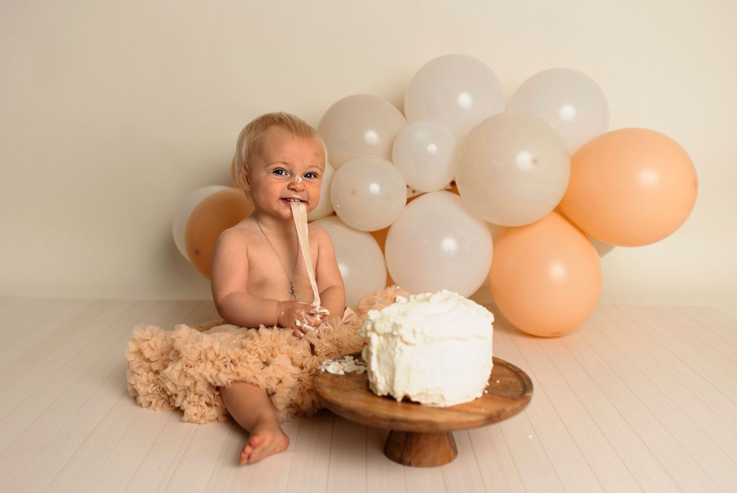 Flicka på sin smash the cake fotografering hos Lovestories By Sara. Flickan har på sig en beige tyllkjol.