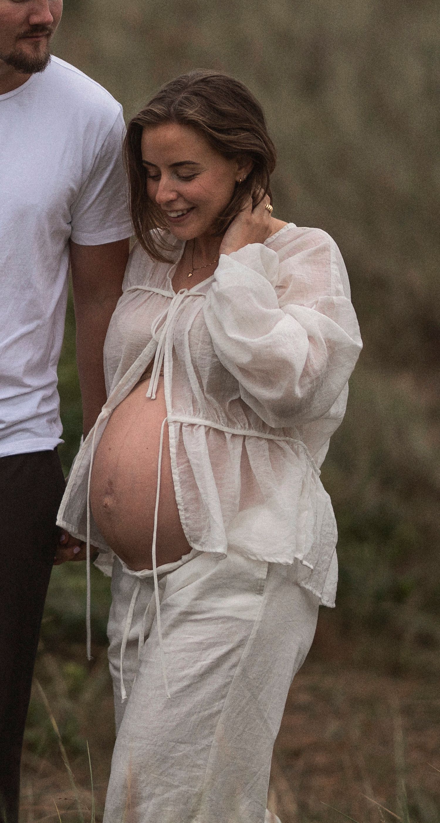 An intimate maternity moment captured in soft natural lighting.