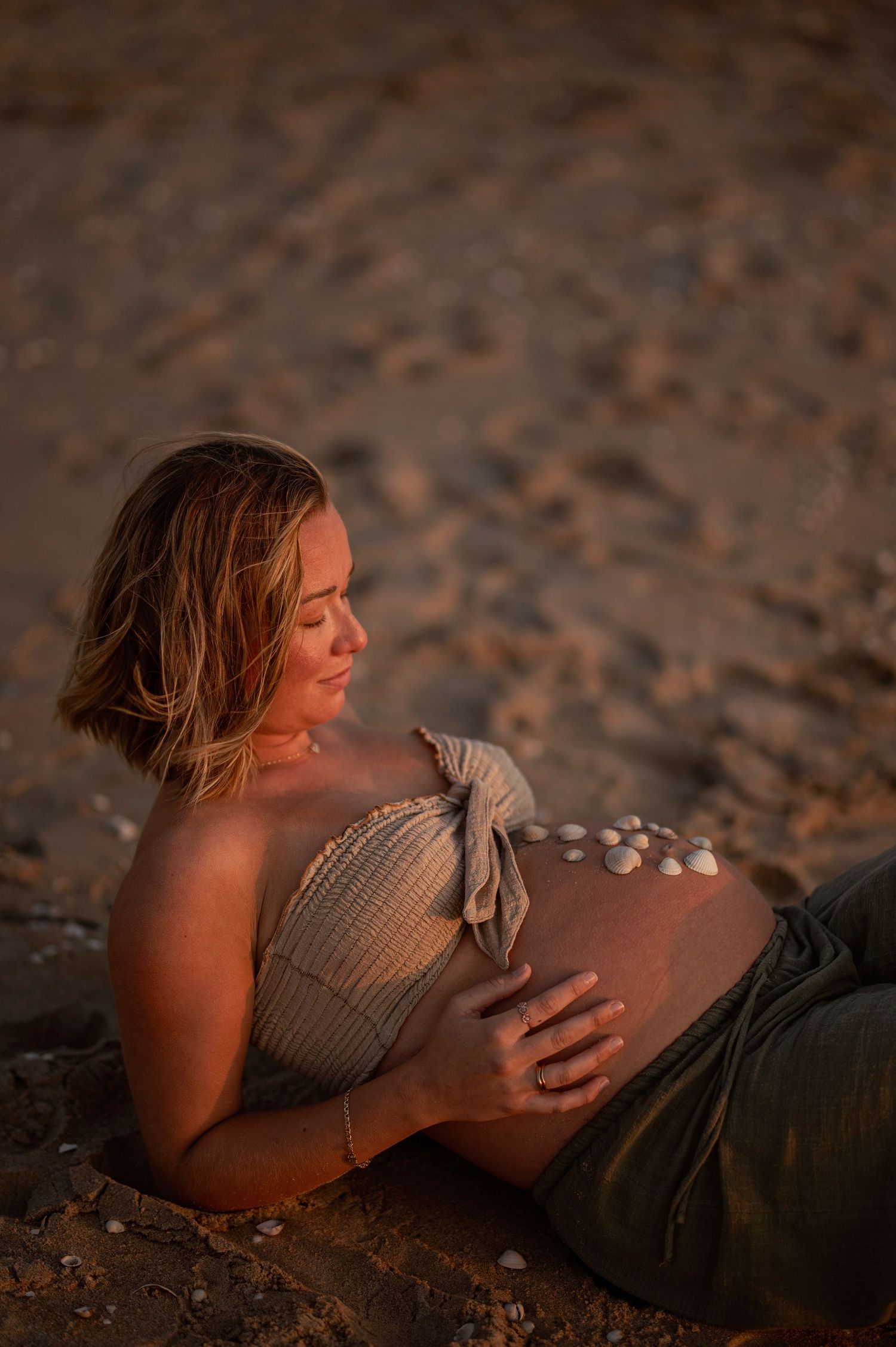 Person laying on a sandy beach at sunset in a series of peaceful poses against warm golden lighting.