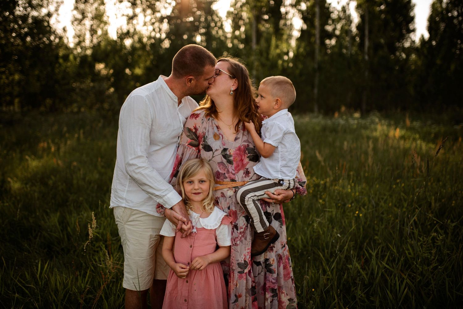 Intimate family moment captured in nature during sunset with pine trees.
