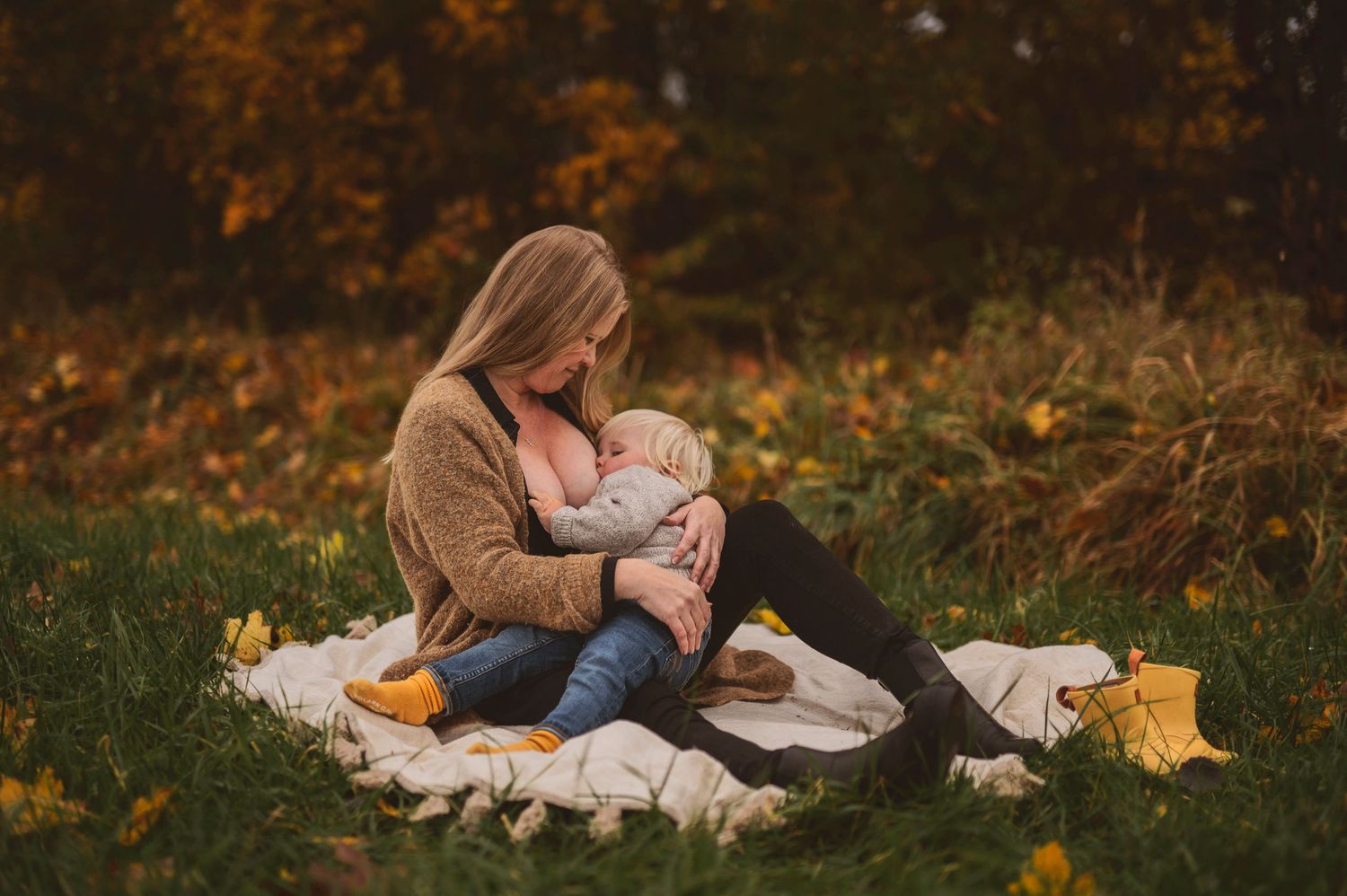 Tender moment shared on a white blanket during a fall afternoon outdoors.