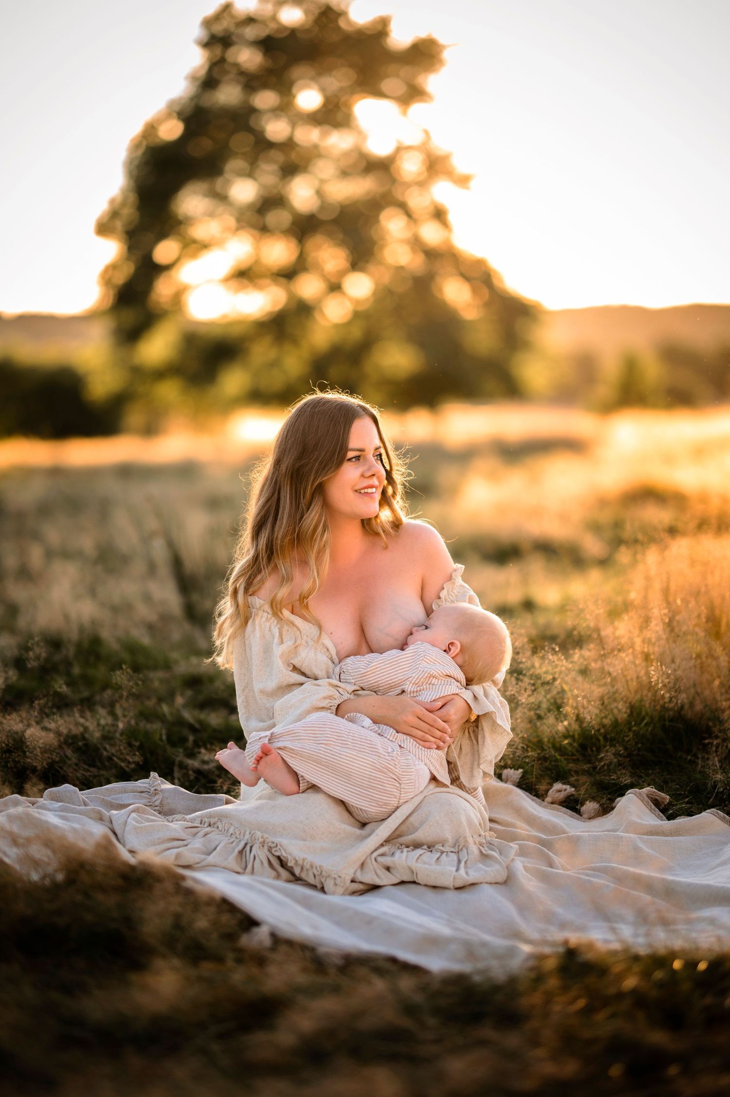 Dreamy outdoor portrait in flowing dress during golden sunset.
