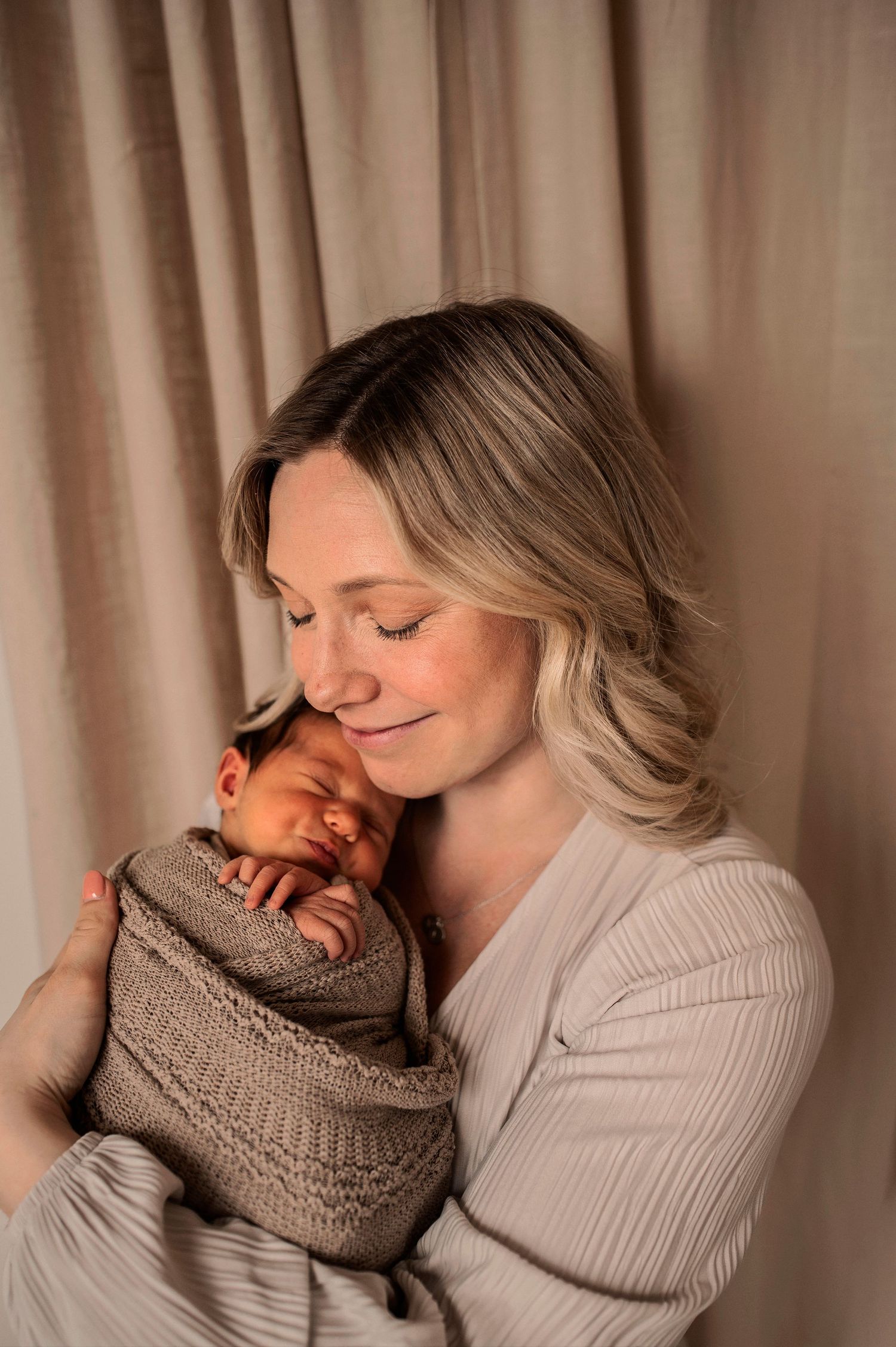 A tender moment captured in warm tones as two people share an intimate embrace while wearing cozy knit sweaters.