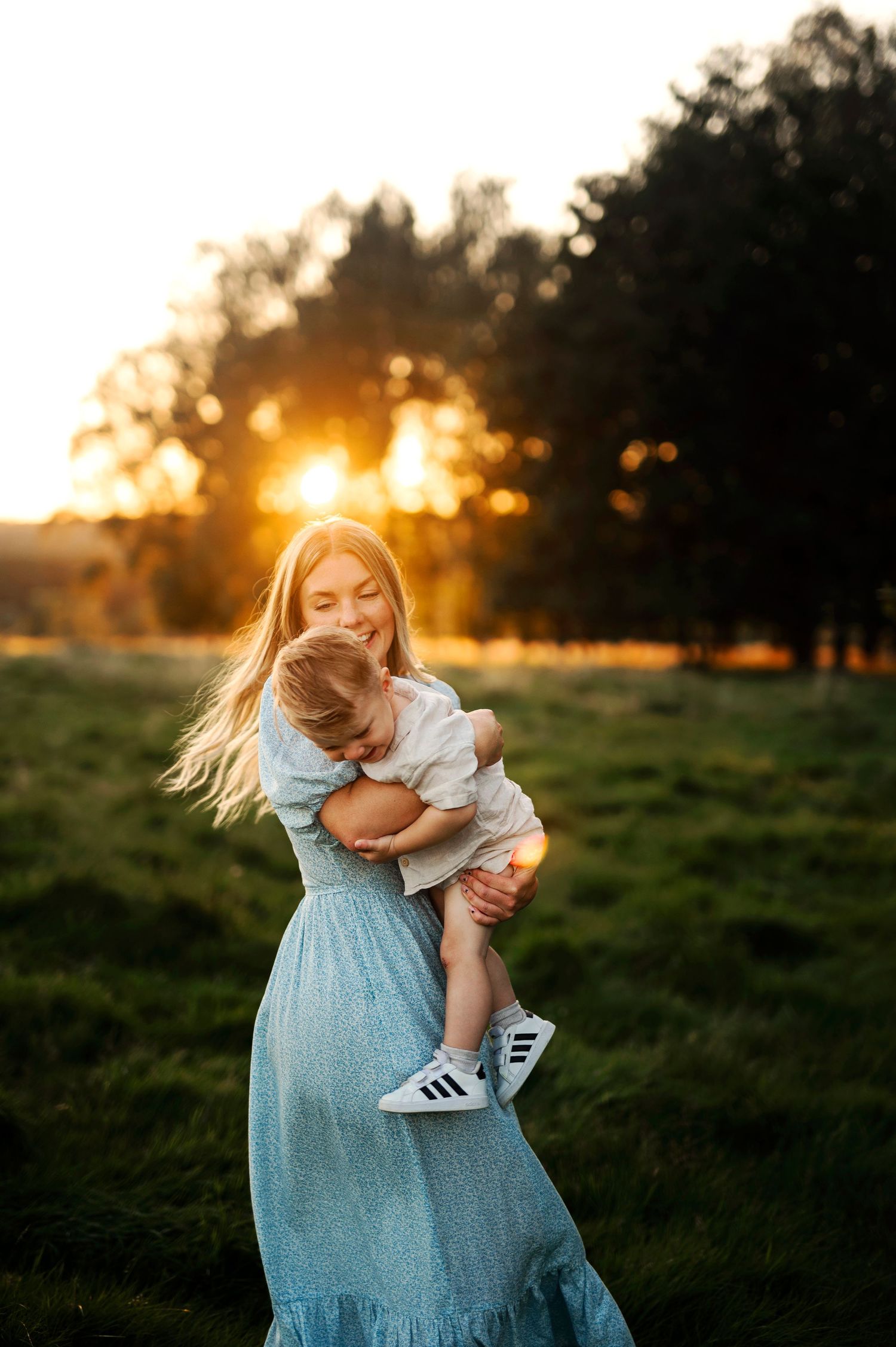 Playful moment captured in a sunlit field with dancing and laughter.