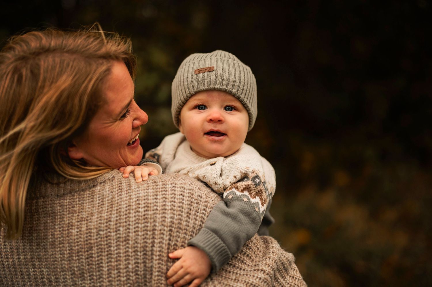 Joyful interaction captured in warm autumn light with matching gray knit accessories.