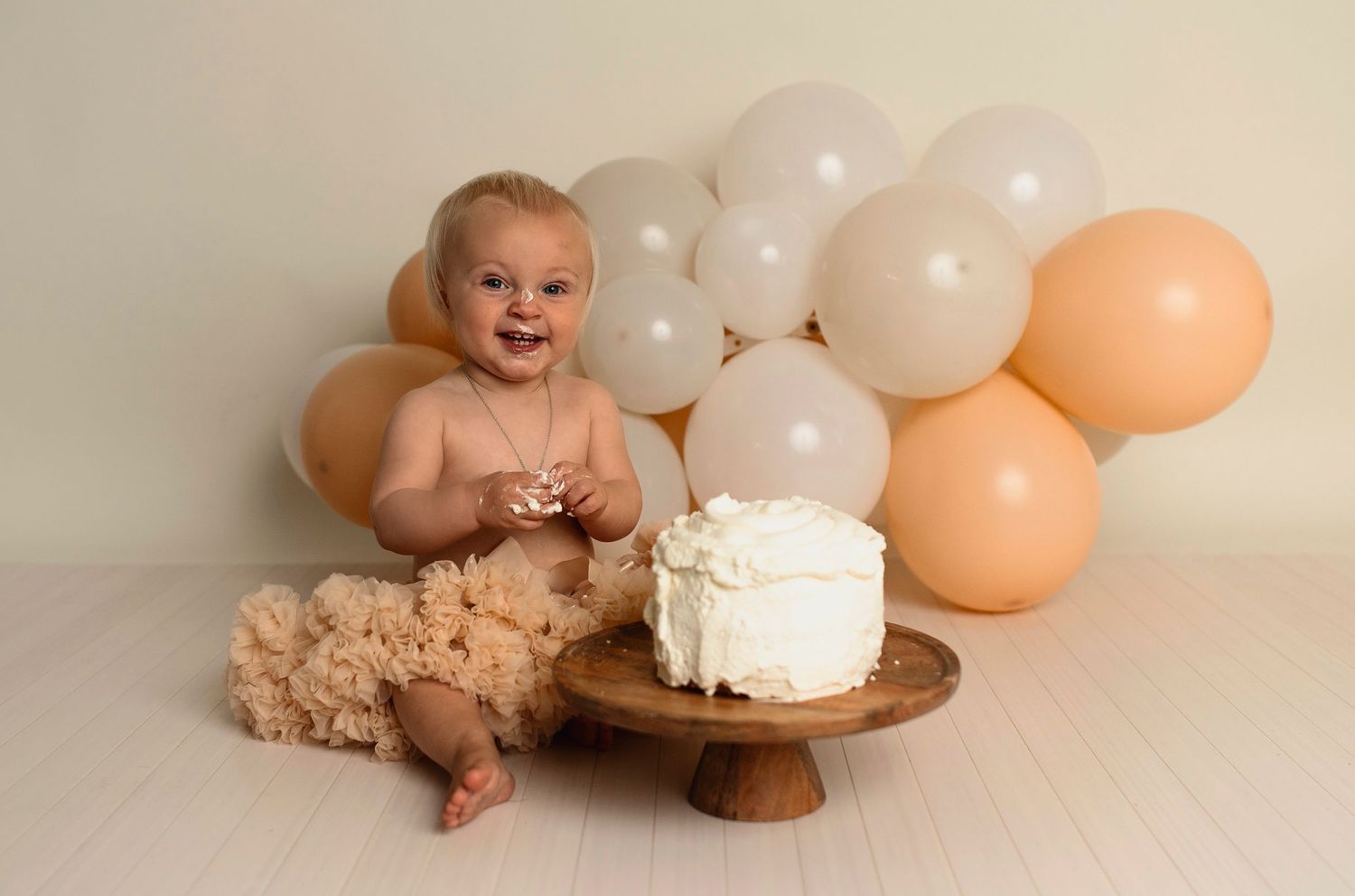 Flicka på sin smash the cake fotografering hos Lovestories By Sara. Flickan har på sig en beige tyllkjol.