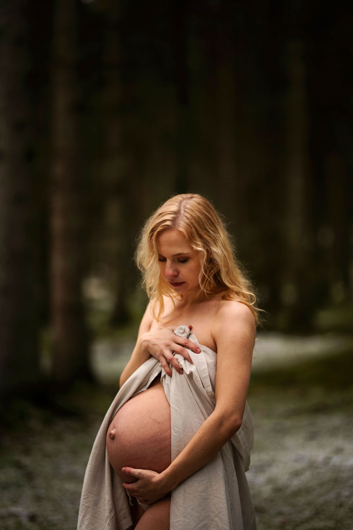 Vacker gravid kvinna på gravidfotografering hos Lovestories By Sara. Nakenfoto i skogen.