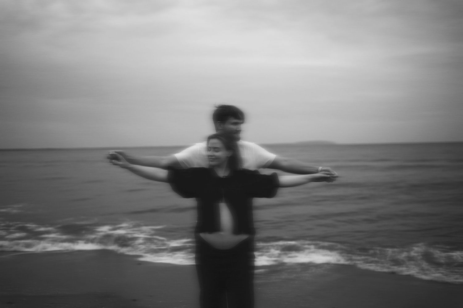Artistic blurred black and white photo of couple by the ocean.