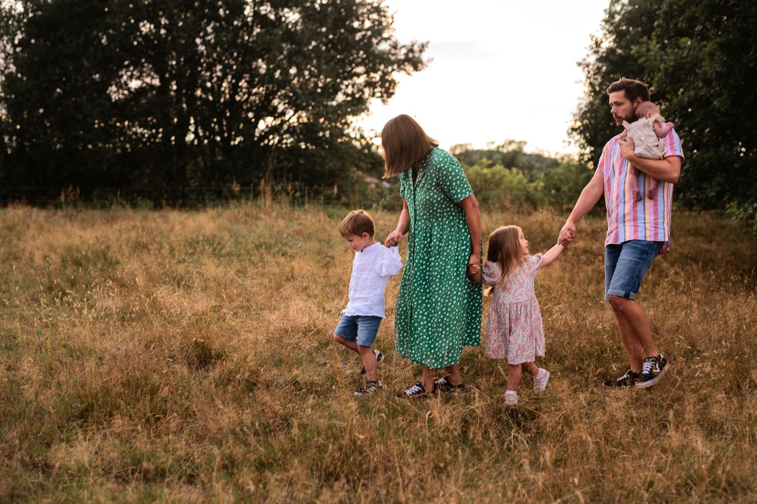 A playful family moment in a summer field during golden hour.