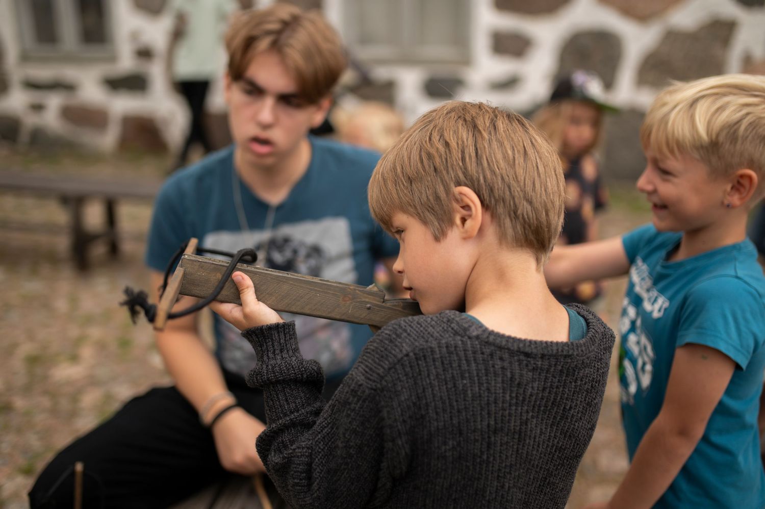 Youth aim and focus during outdoor target practice activity.