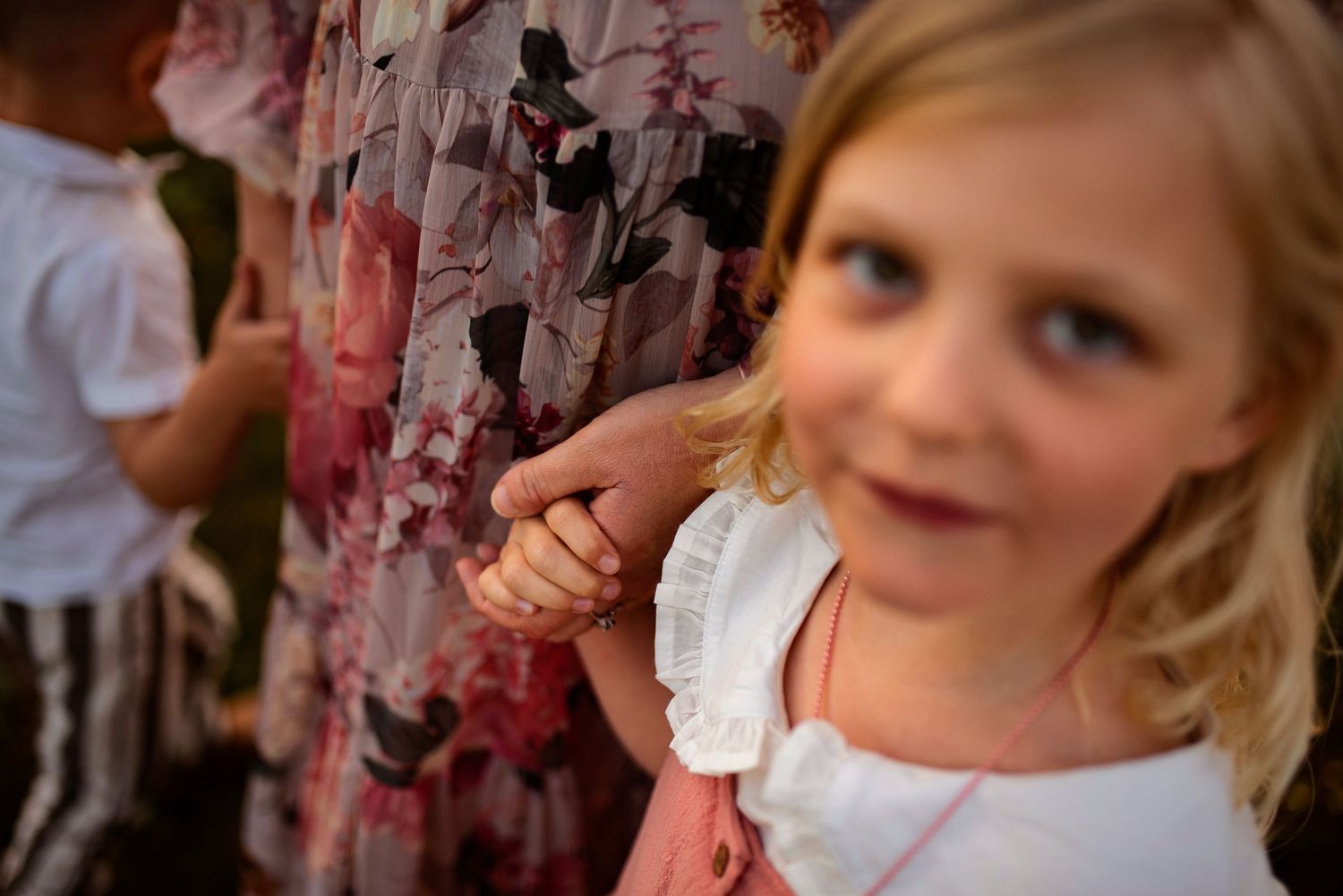 Close-up detail of floral dress fabric and pink clothing in outdoor setting.